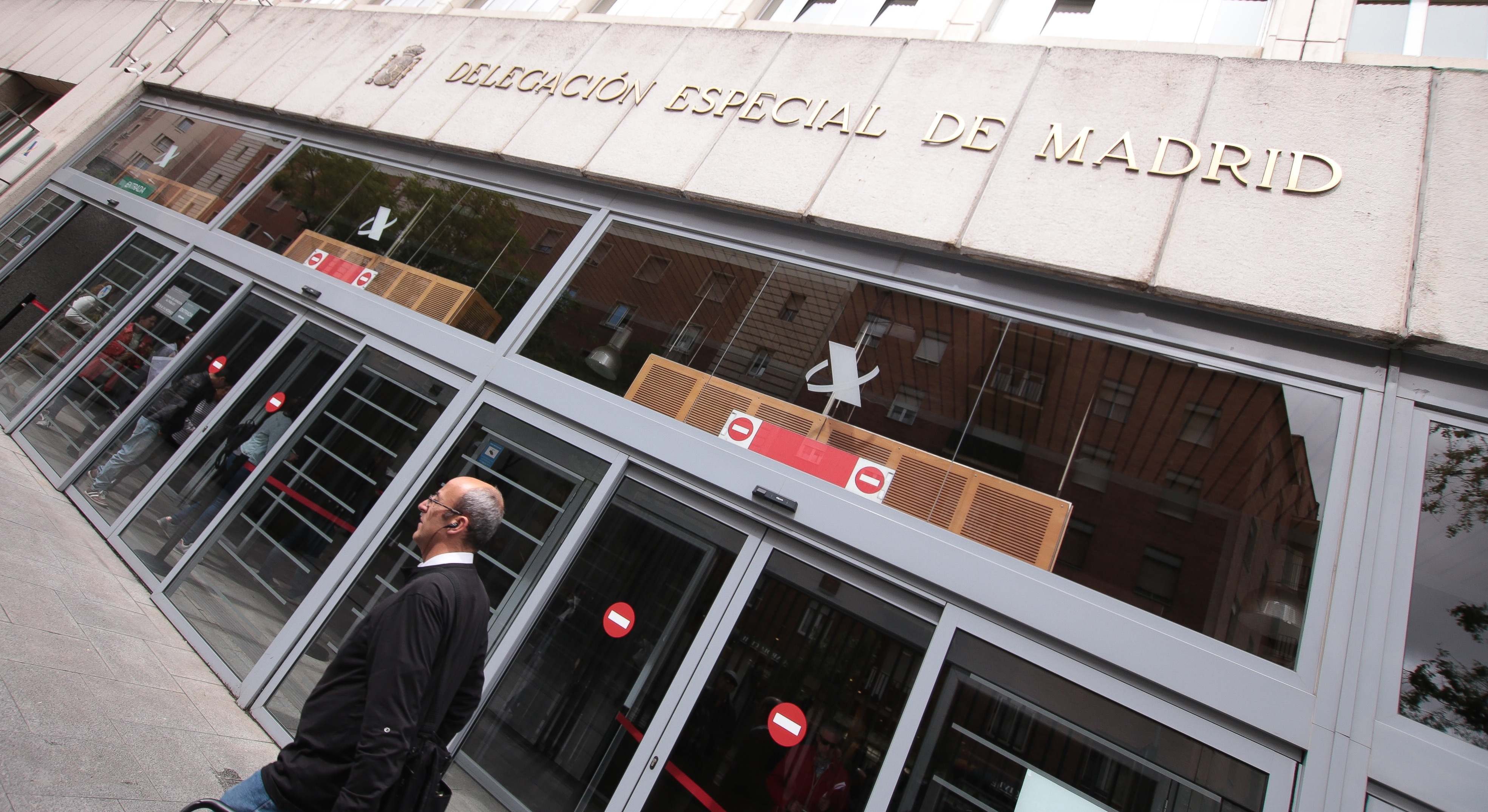 Un hombre camina por delante de una delegación de la Agencia Tributaria