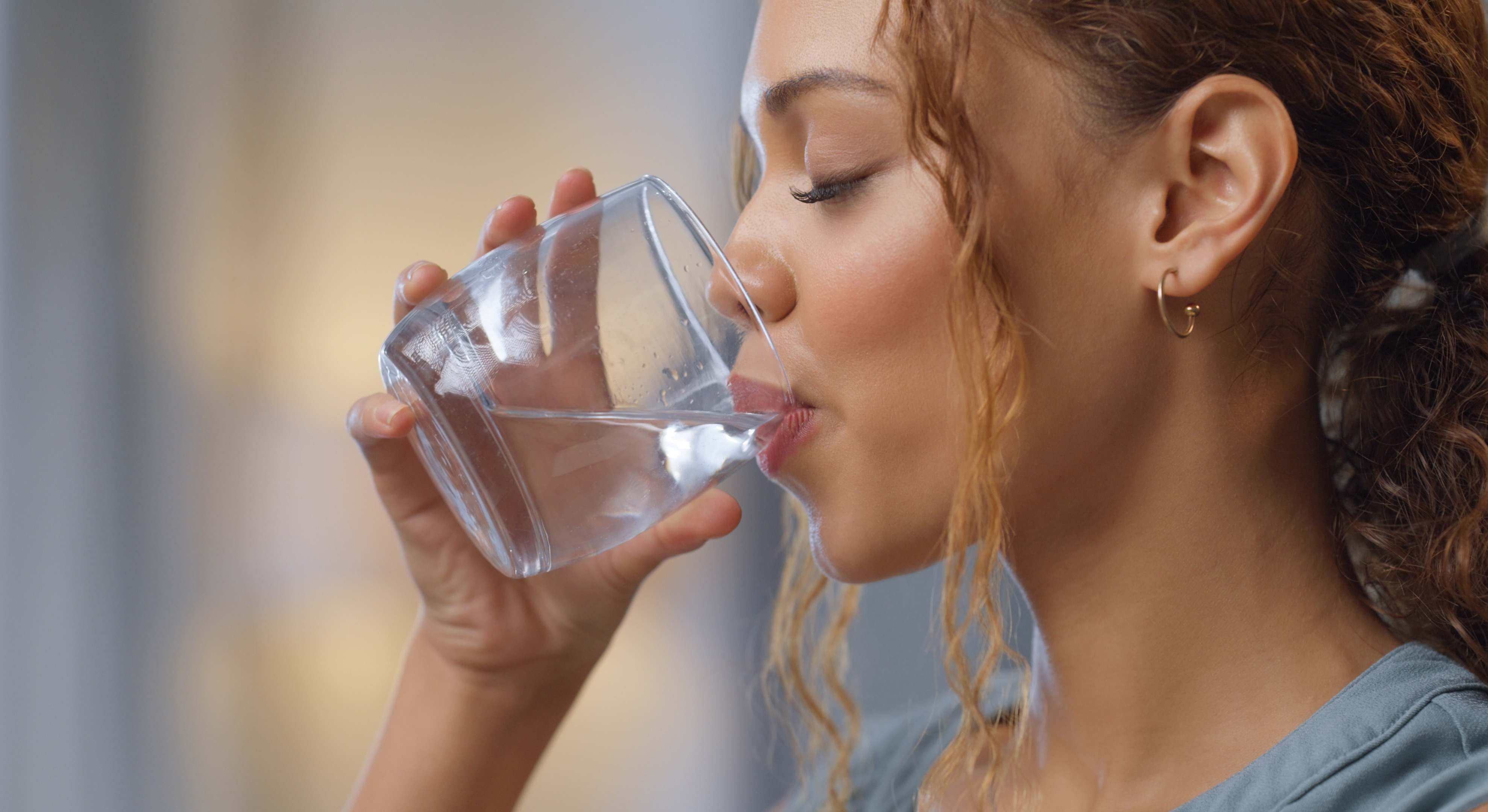 Una mujer bebiendo un vaso de agua