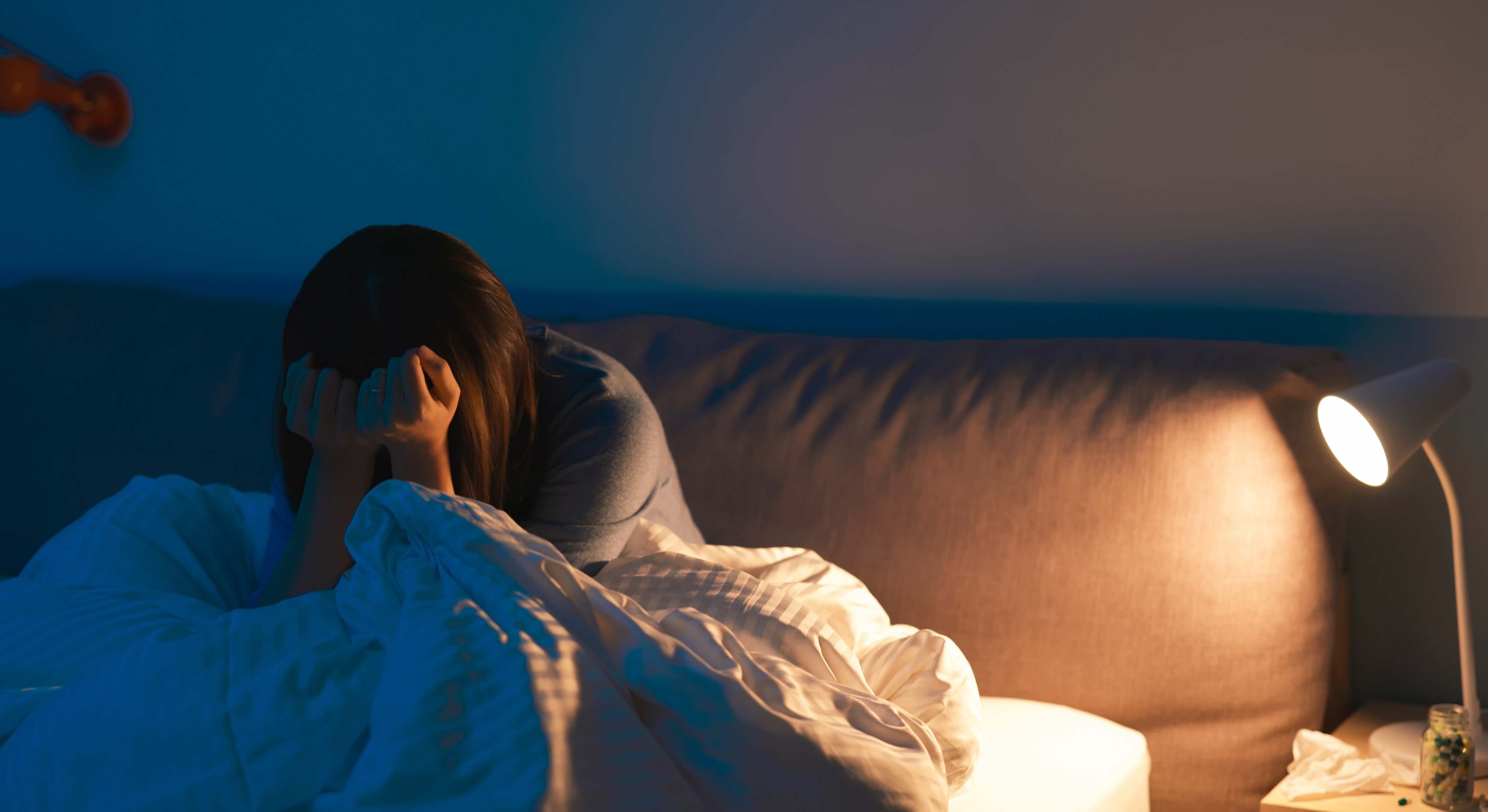 Mujer frustrada en su dormitorio por no poder dormir