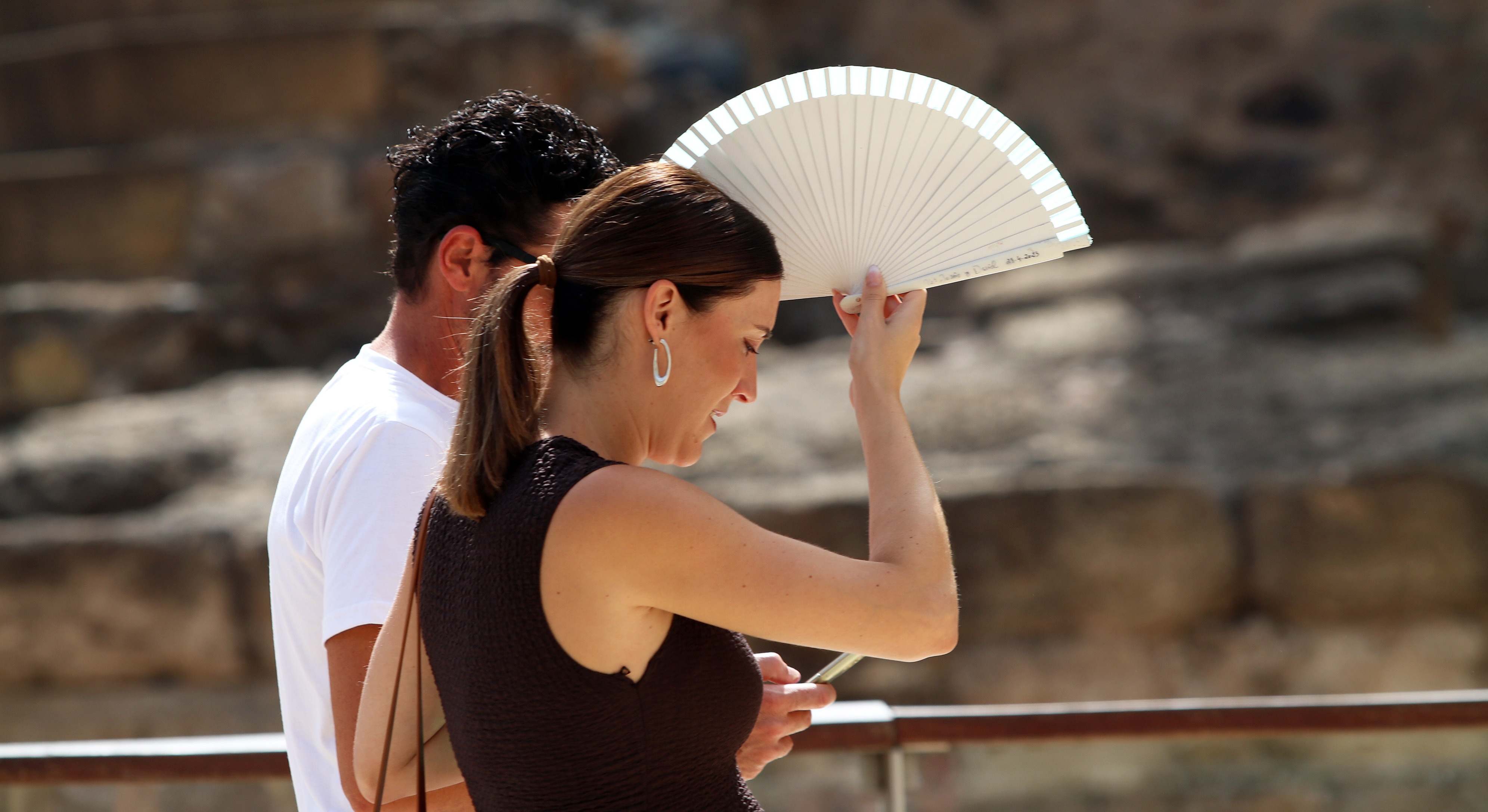 Imagen de dos personas protegiéndose del calor en Málaga.