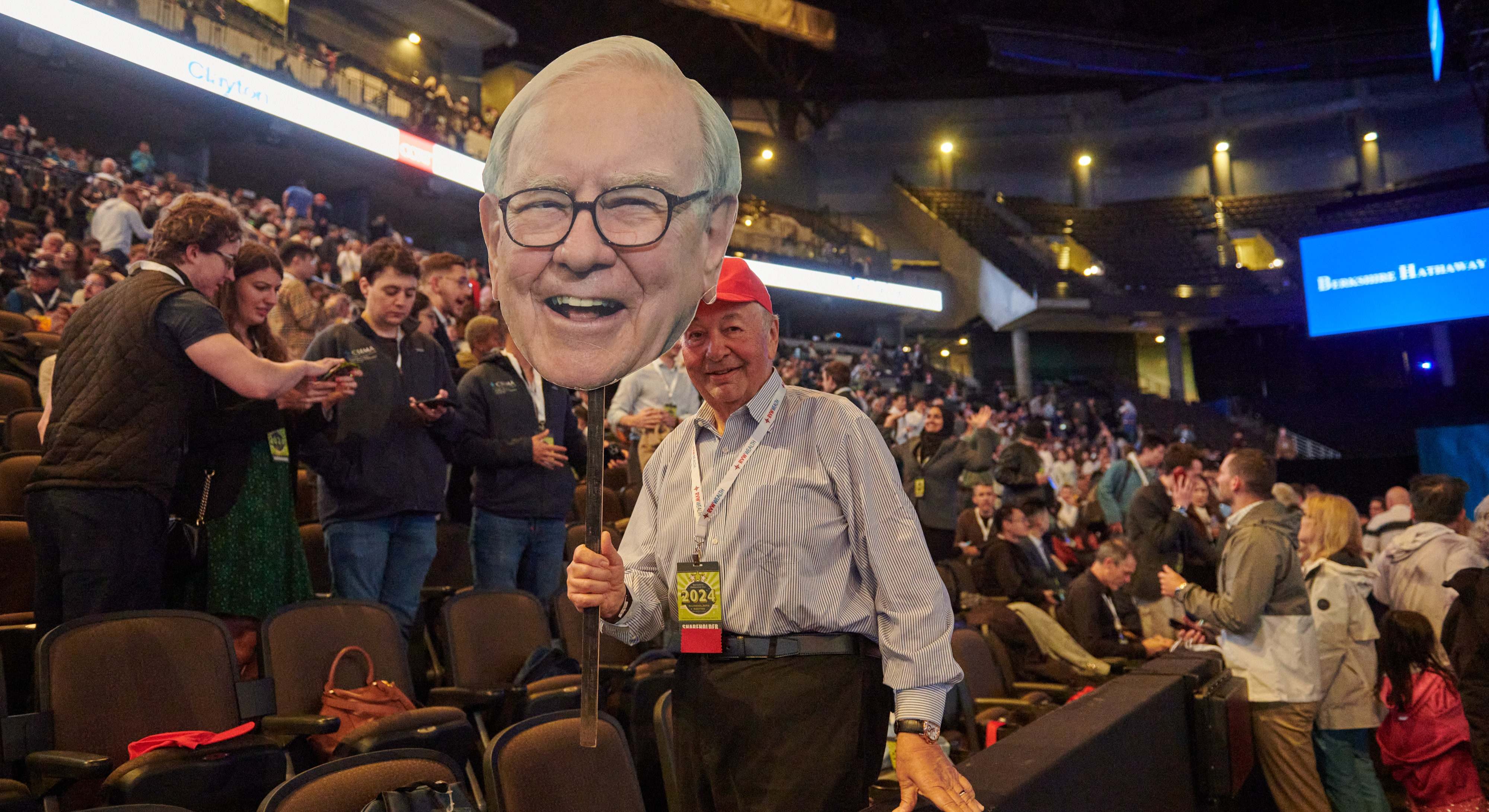 Un accionista de Berkshire Hathaway sujetando una efigie de cartón de Buffett.