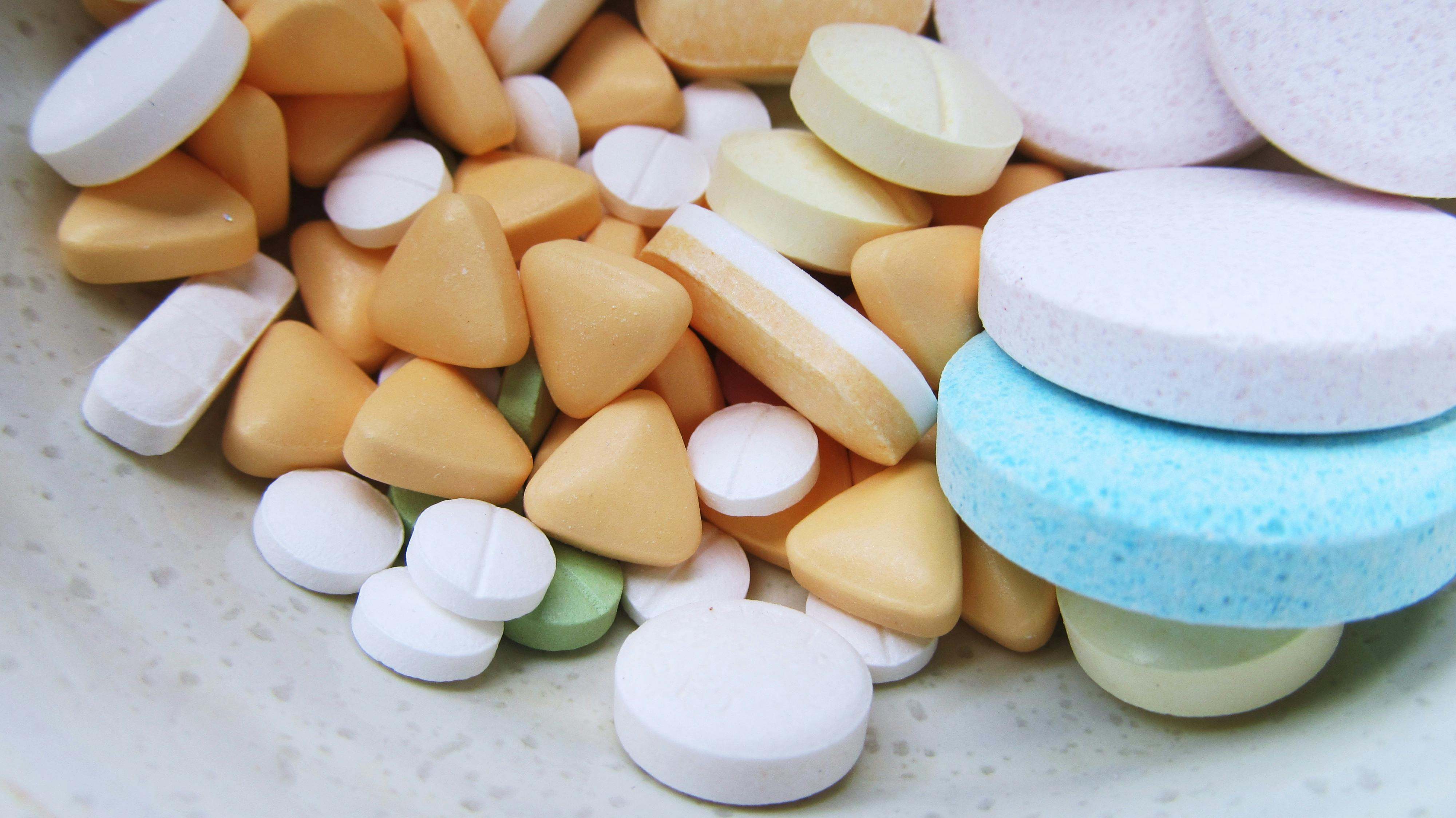 Varias pastillas juntas, sobre la mesa de una farmacia