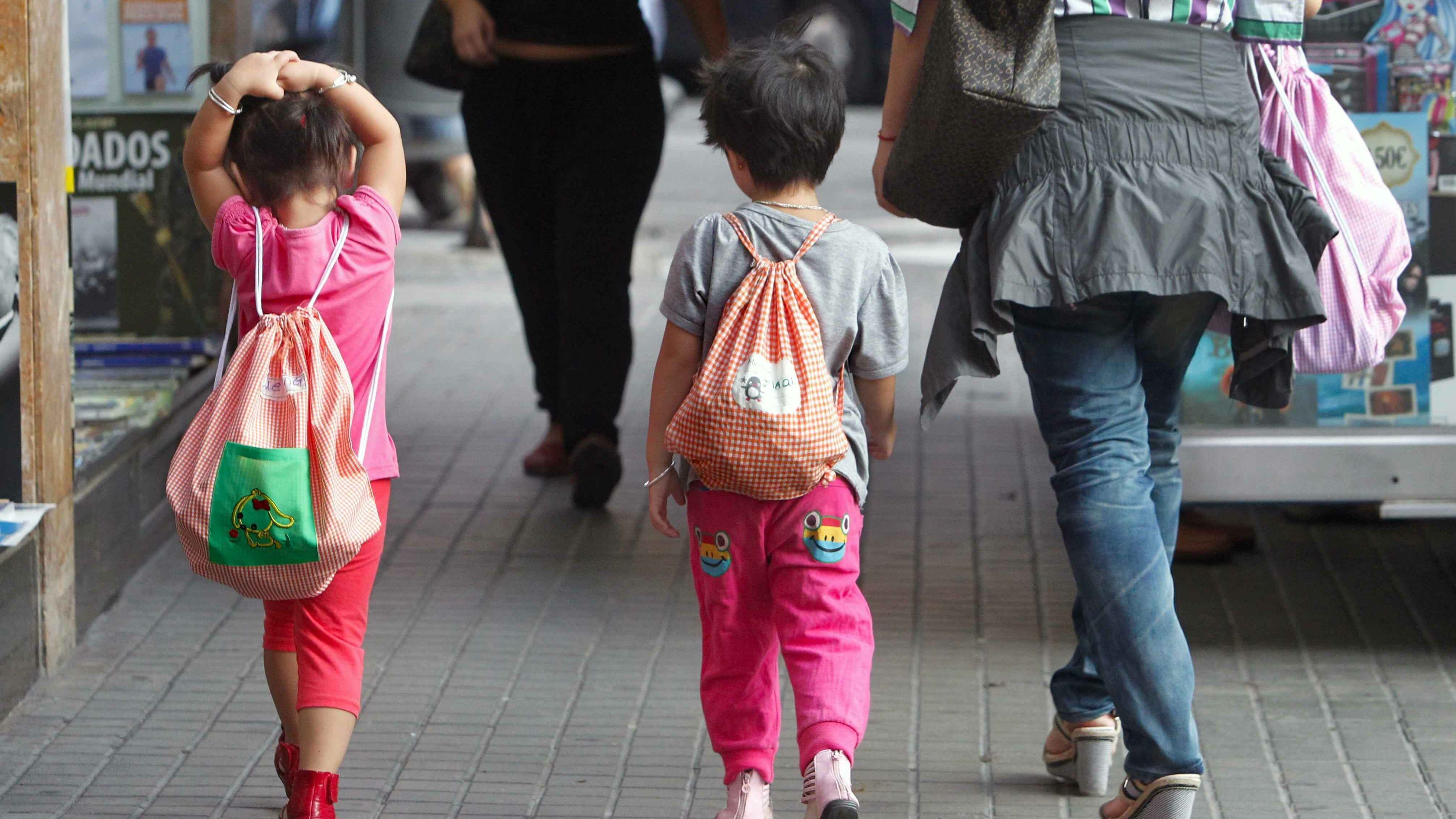 Una mujer pasea con dos niños