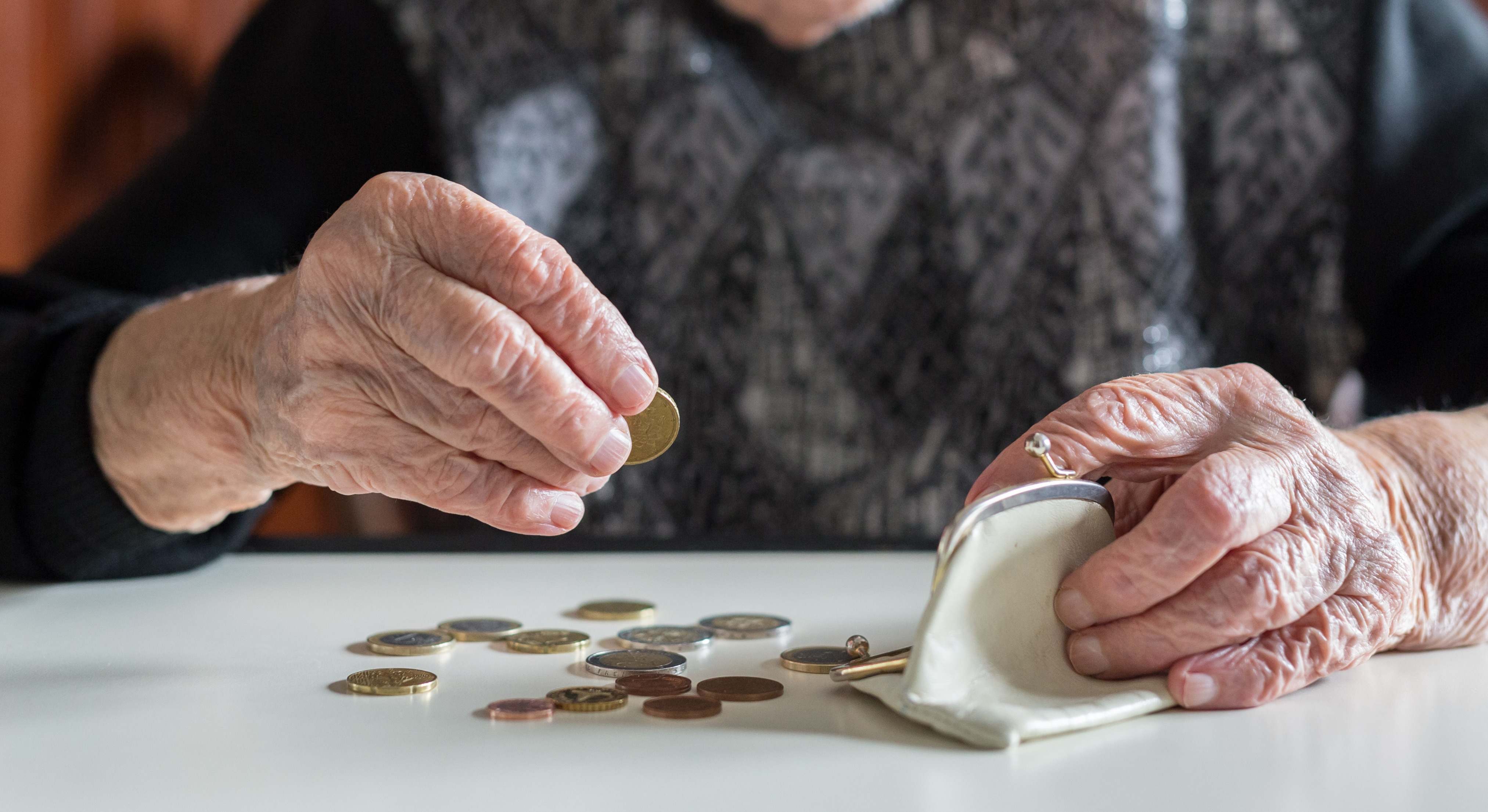 Una persona mayor cuenta monedas