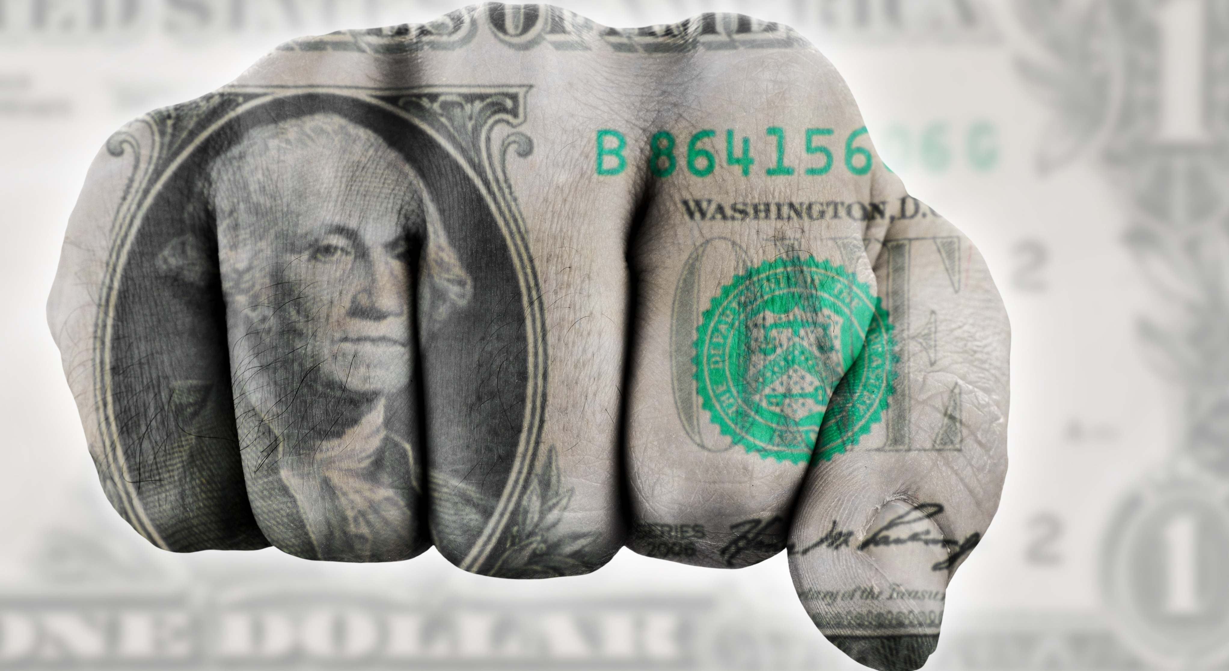 Un puño con detalles del billete de 1 dólar reflejados