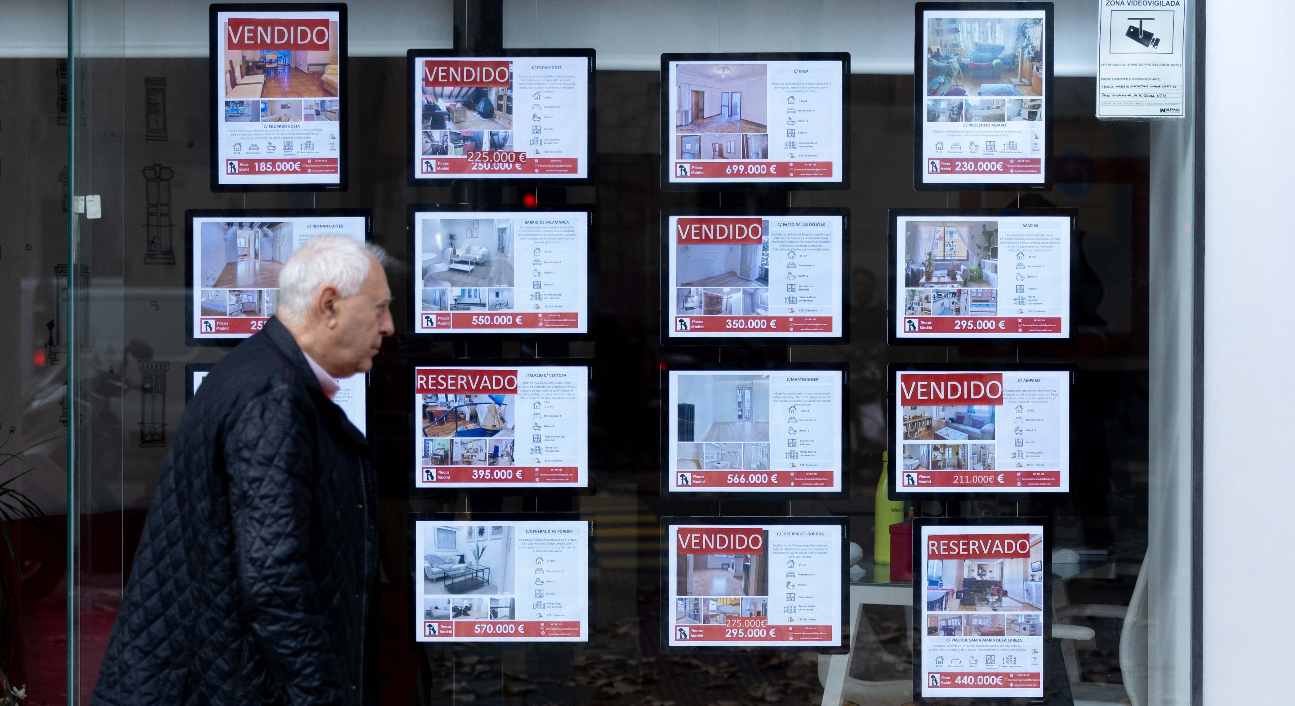 Hombre frente a anuncios de una inmobiliaria