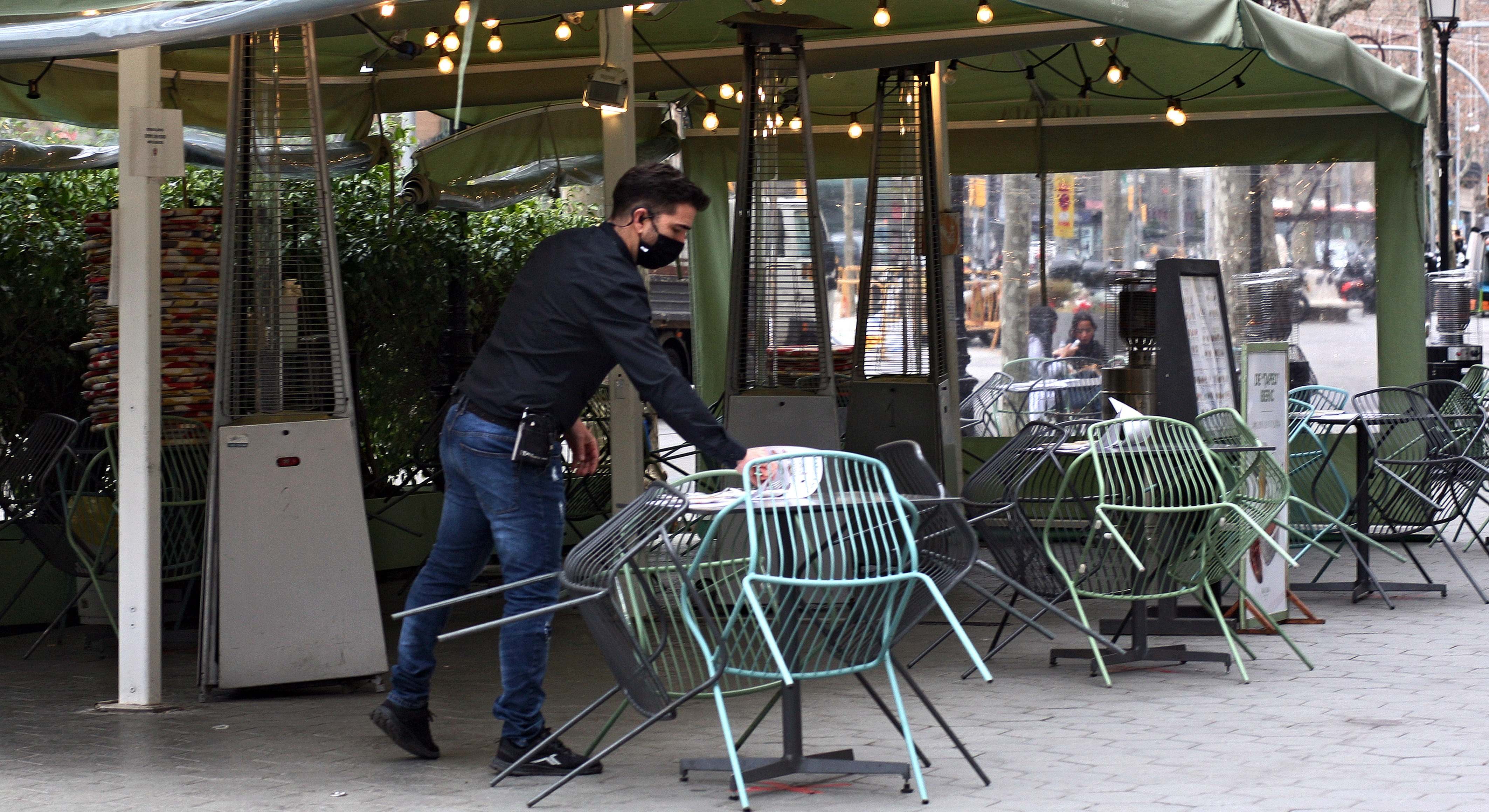 Un trabajador recoge una terraza durante la pandemia