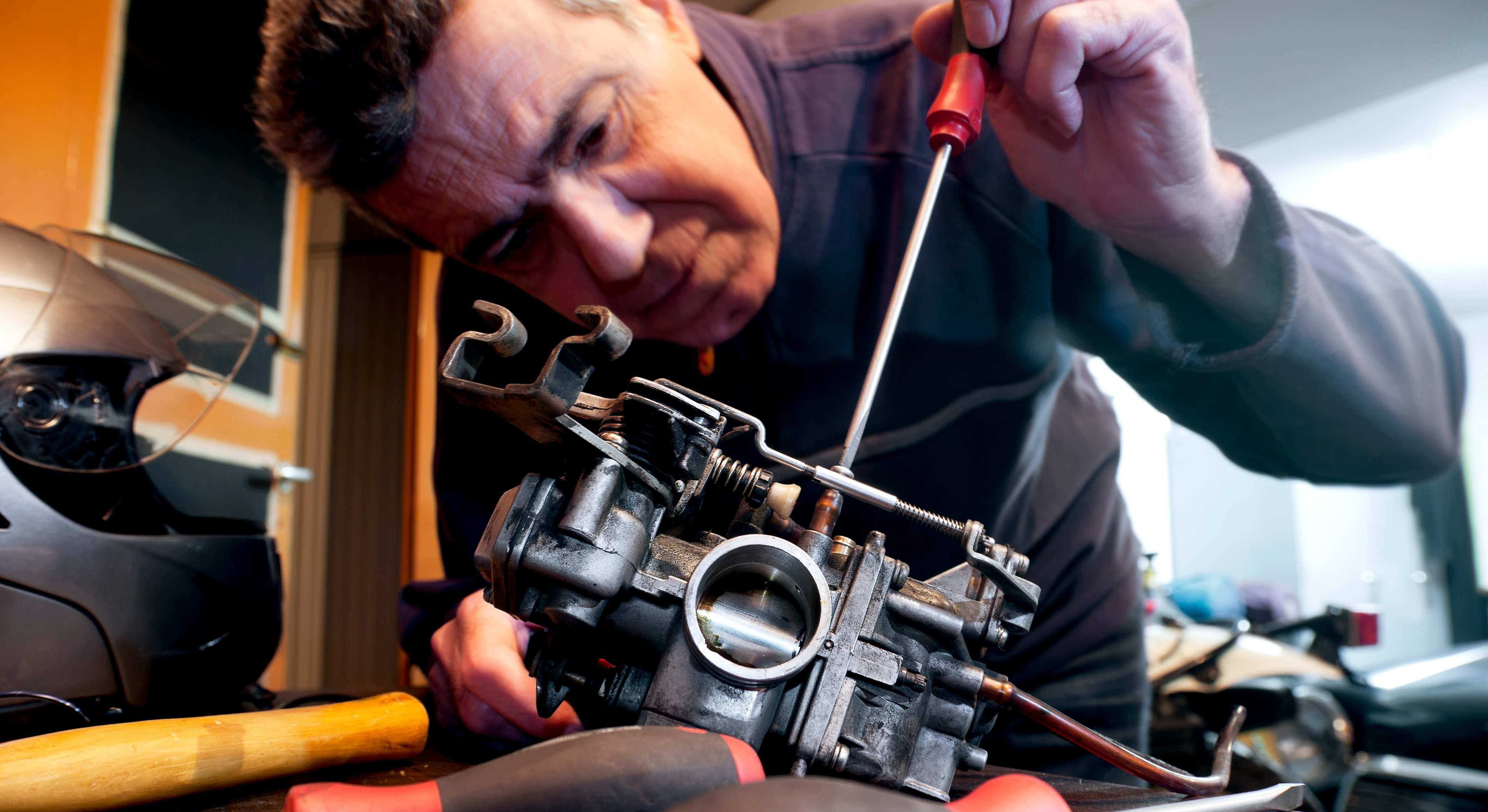 Mecánico reparando el carburador de una motocicleta