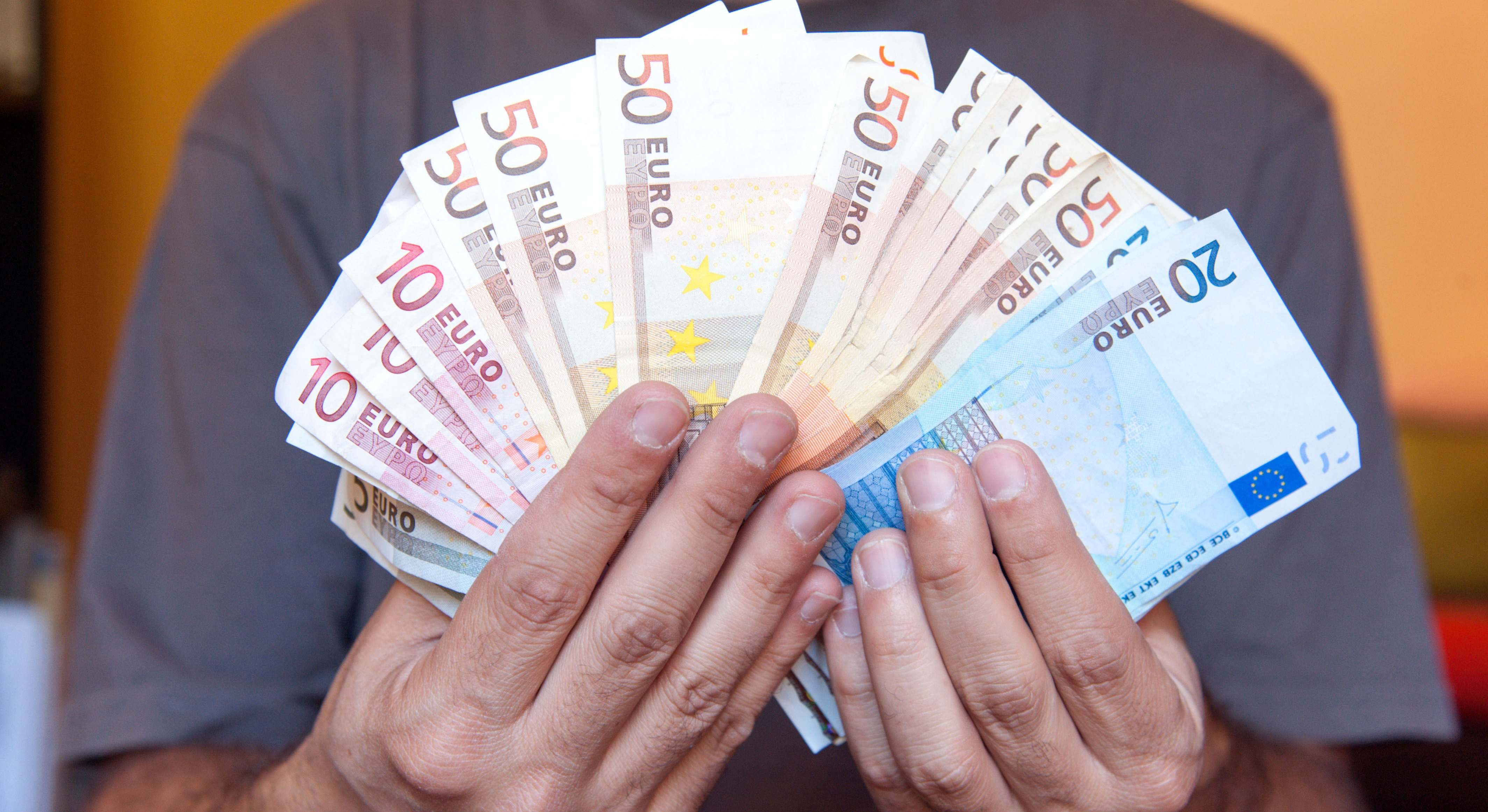 Un joven sosteniendo billetes de euro