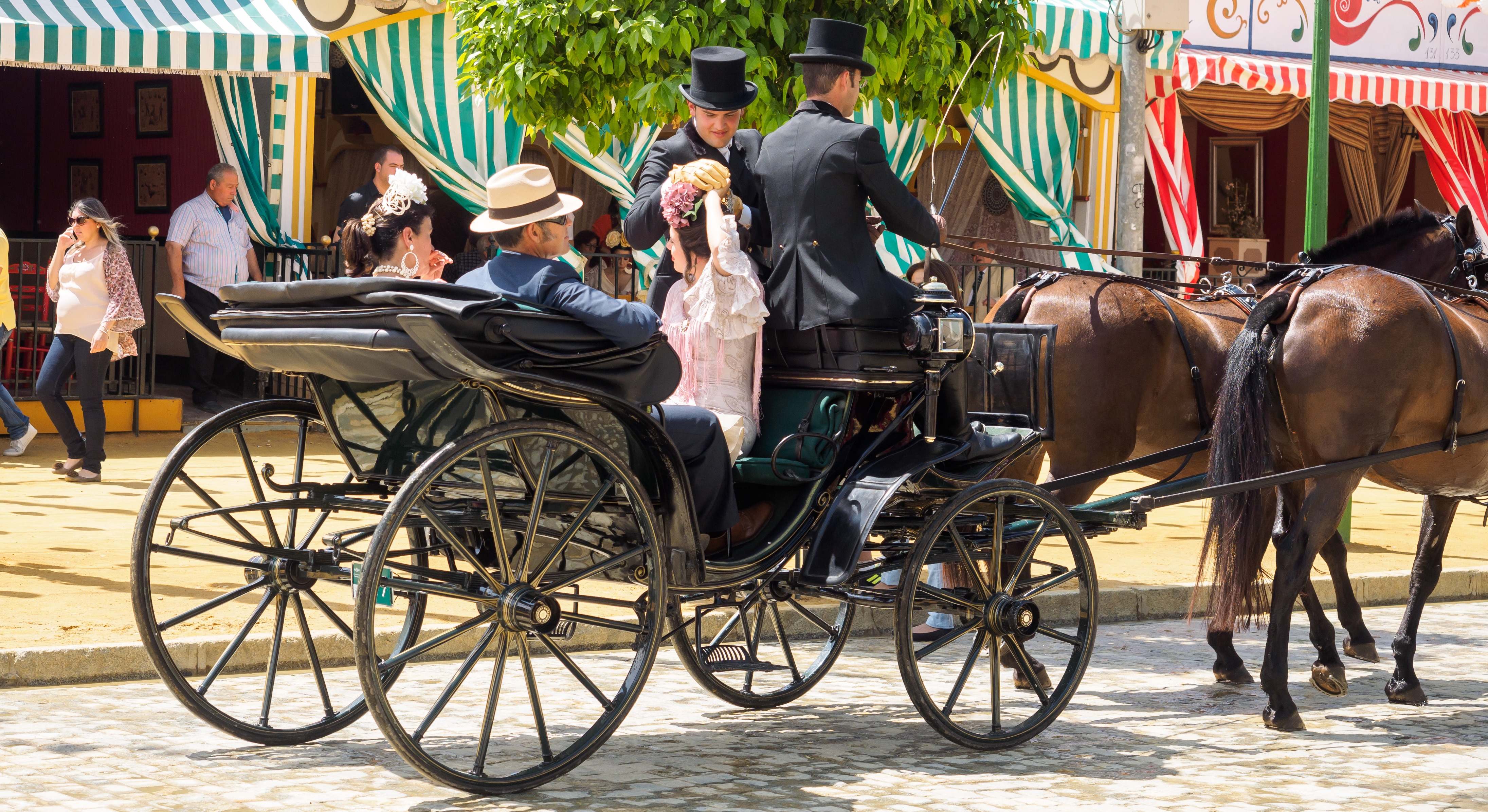 Personas en vestido tradicional en un carruaje de caballos