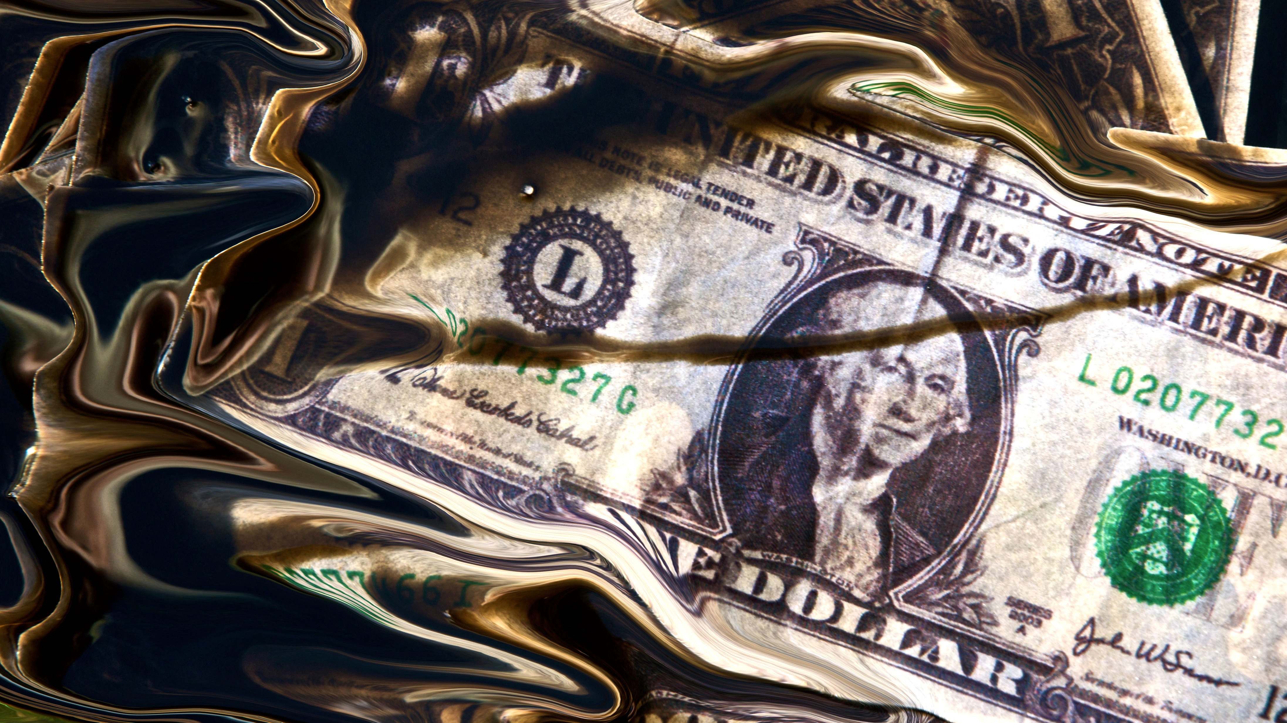 Billete de dólar en un charco de petróleo