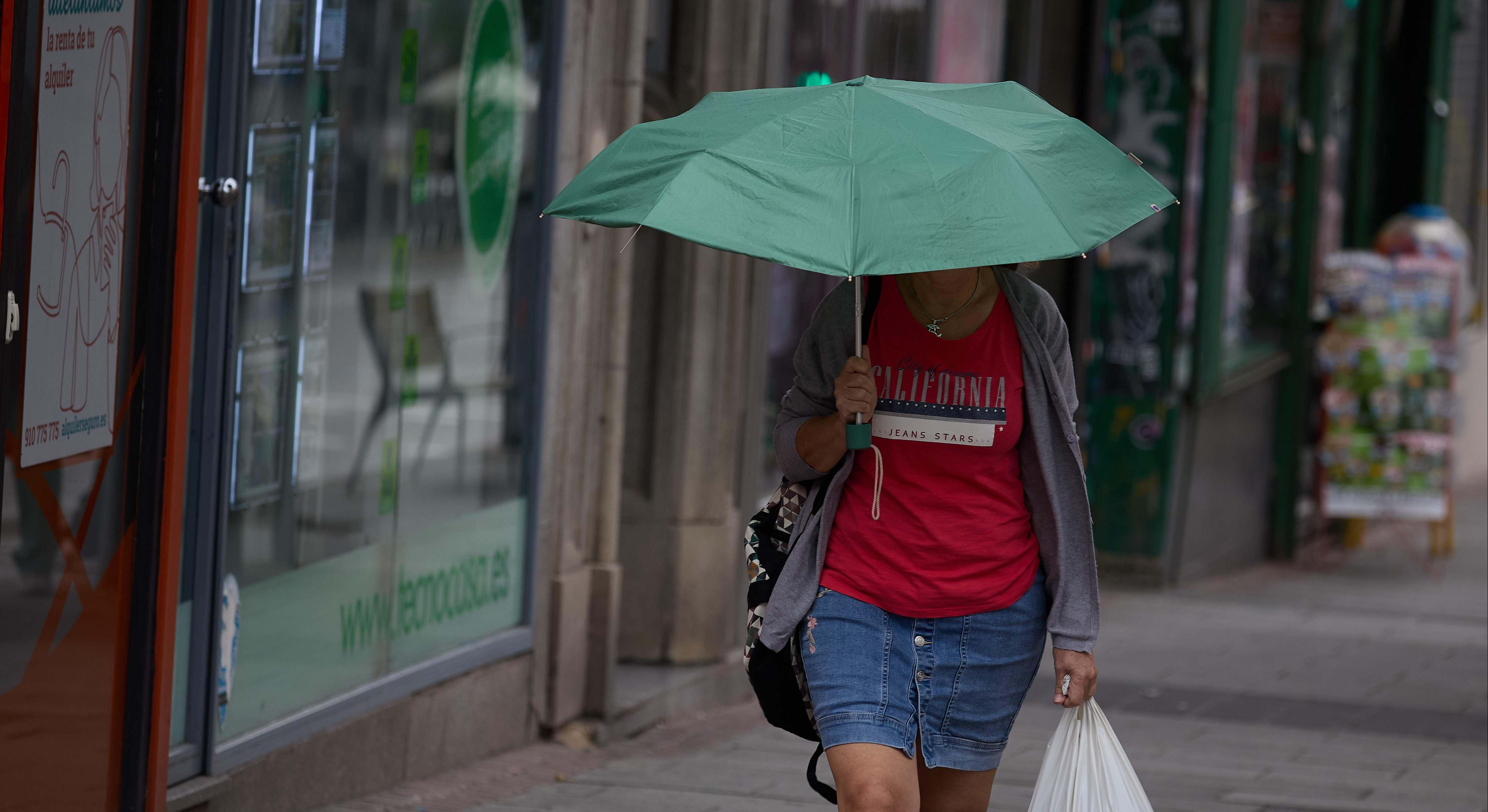 Una mujer se protege de la lluvia con un paraguas, a 8 de junio de 2024, en Madrid