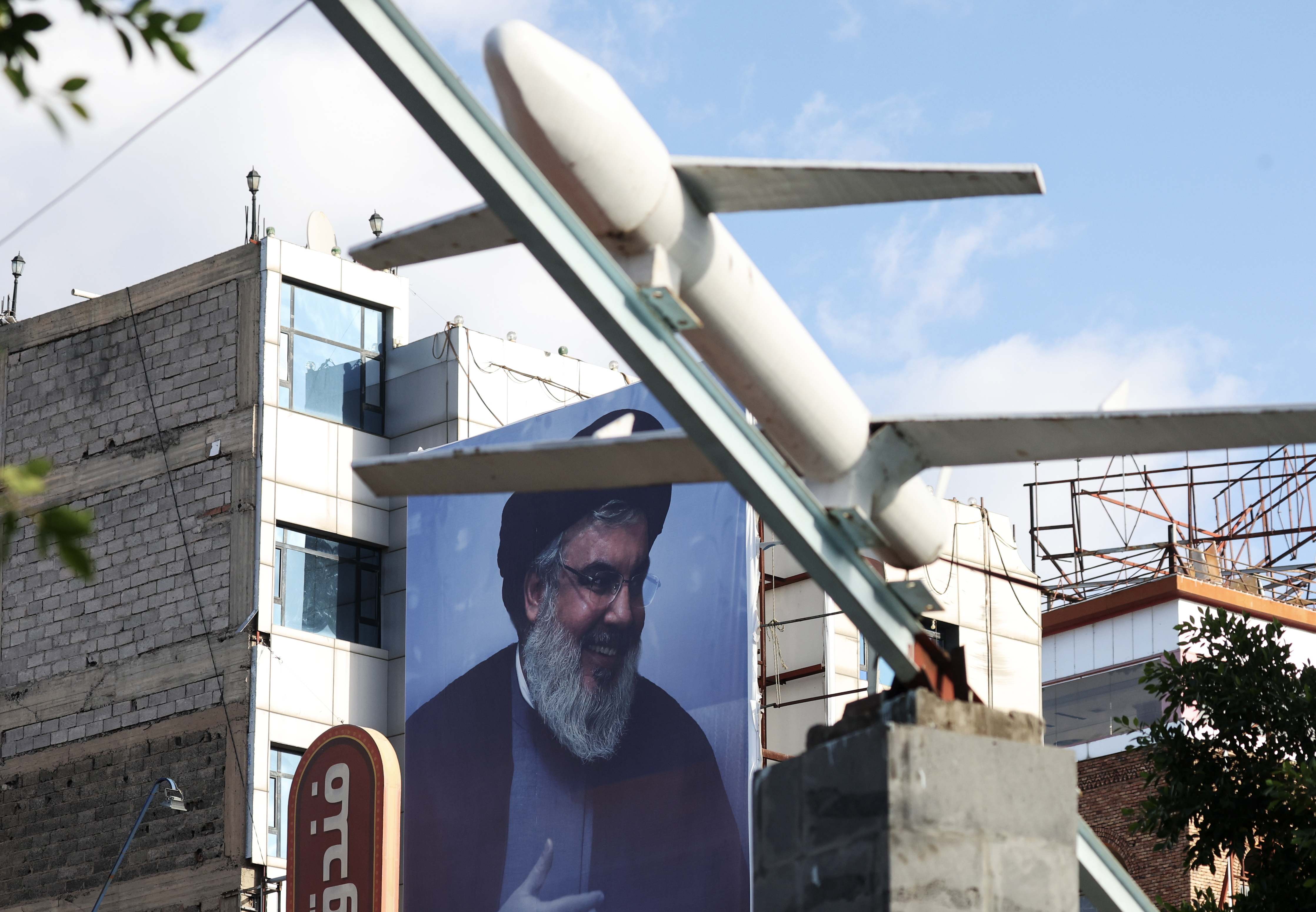 Un dron simulado fabricado por los hutíes se exhibe frente a una valla publicitaria con un retrato del difunto líder de Hezbolá, Hassan Nasrallah, en una plaza de Saná, Yemen, el 22 de octubre de 2024