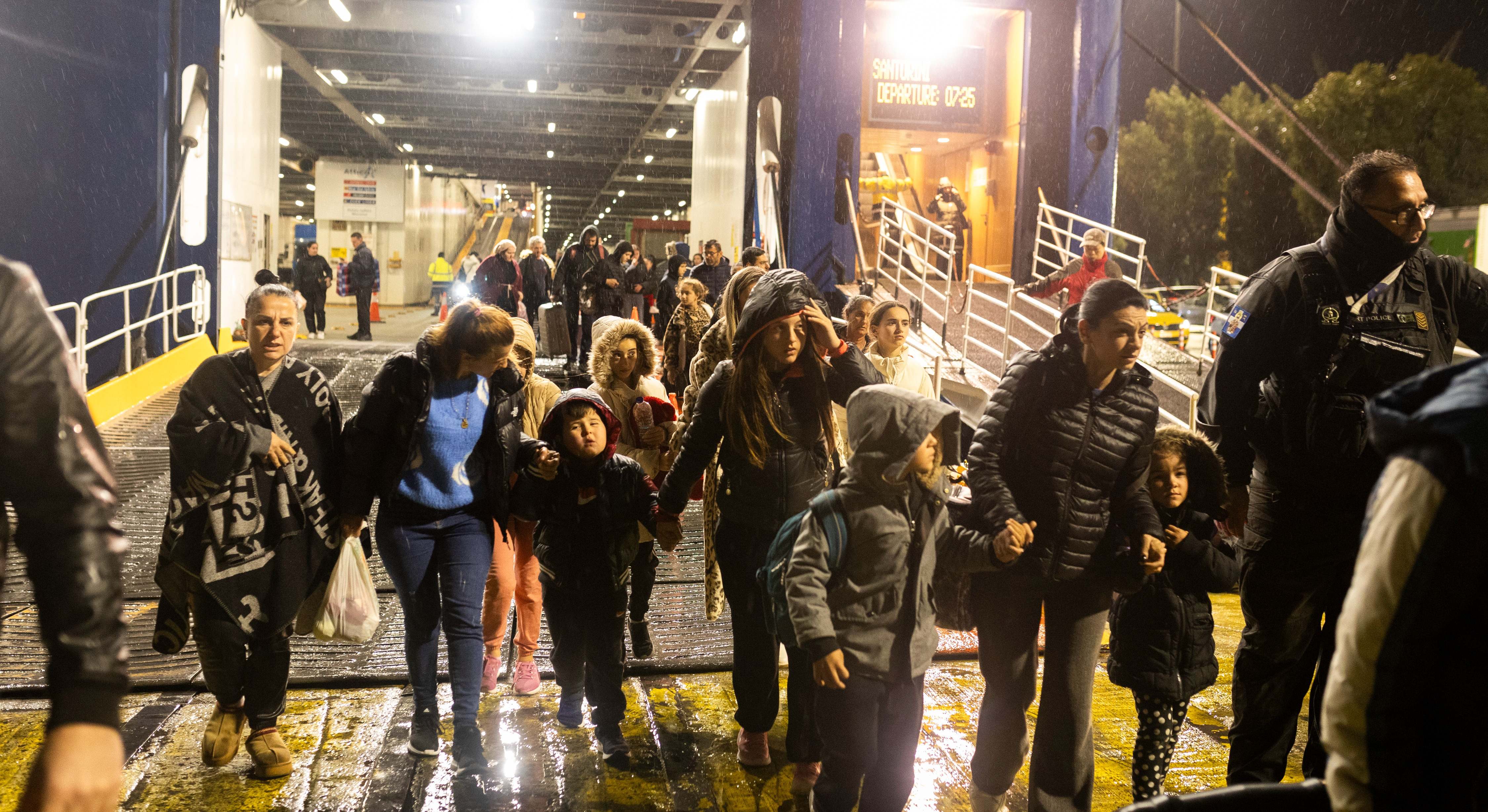 Un grupo de personas desembarca de un ferry en el puerto de El Pireo, cerca de Atenas, tras salir de la isla griega de Santorini.