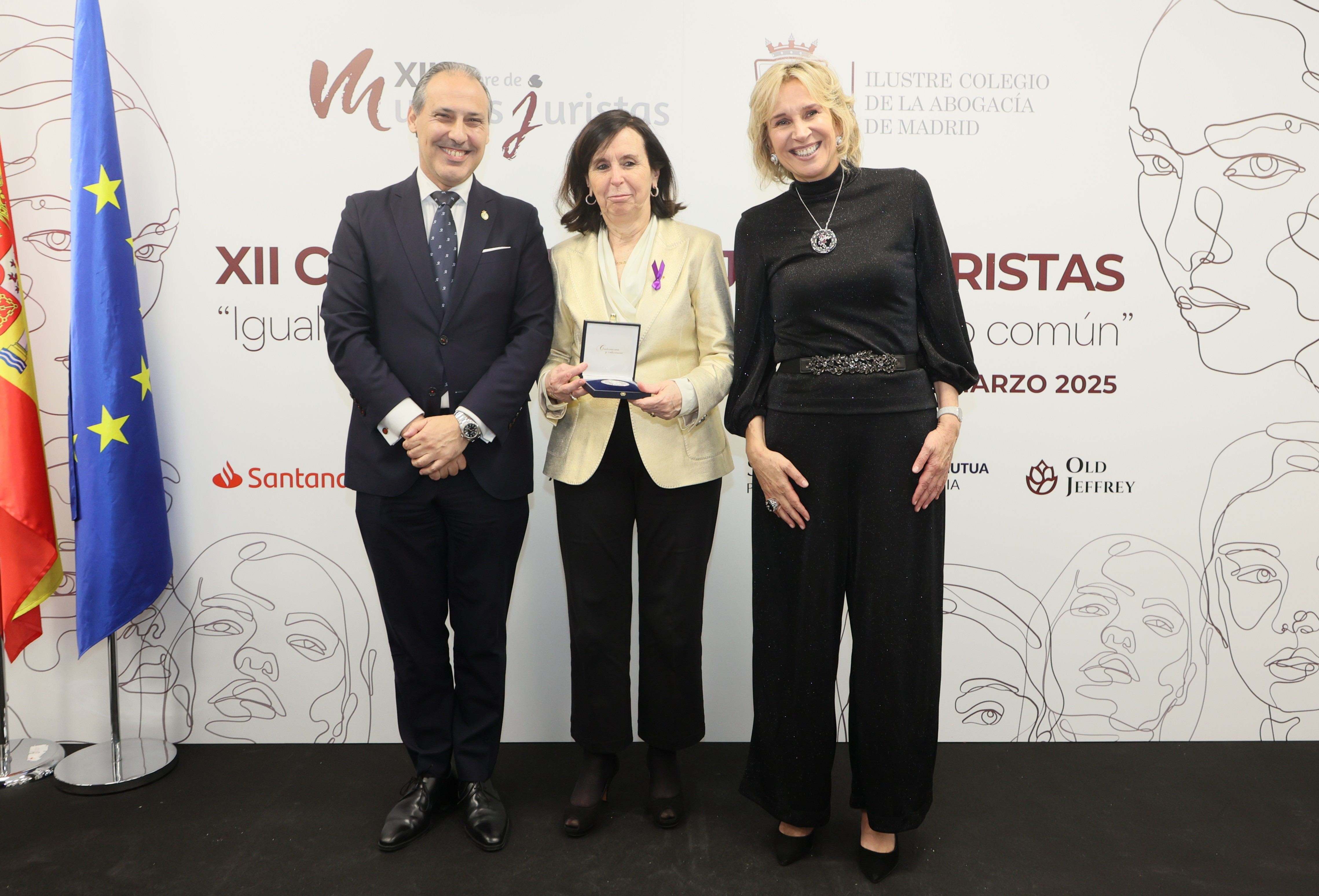 María Emilia Casas (centro) recibe el galardón de mano del decano del ICAM, Eugenio Ribón y la vicedecana Isabel Winkels