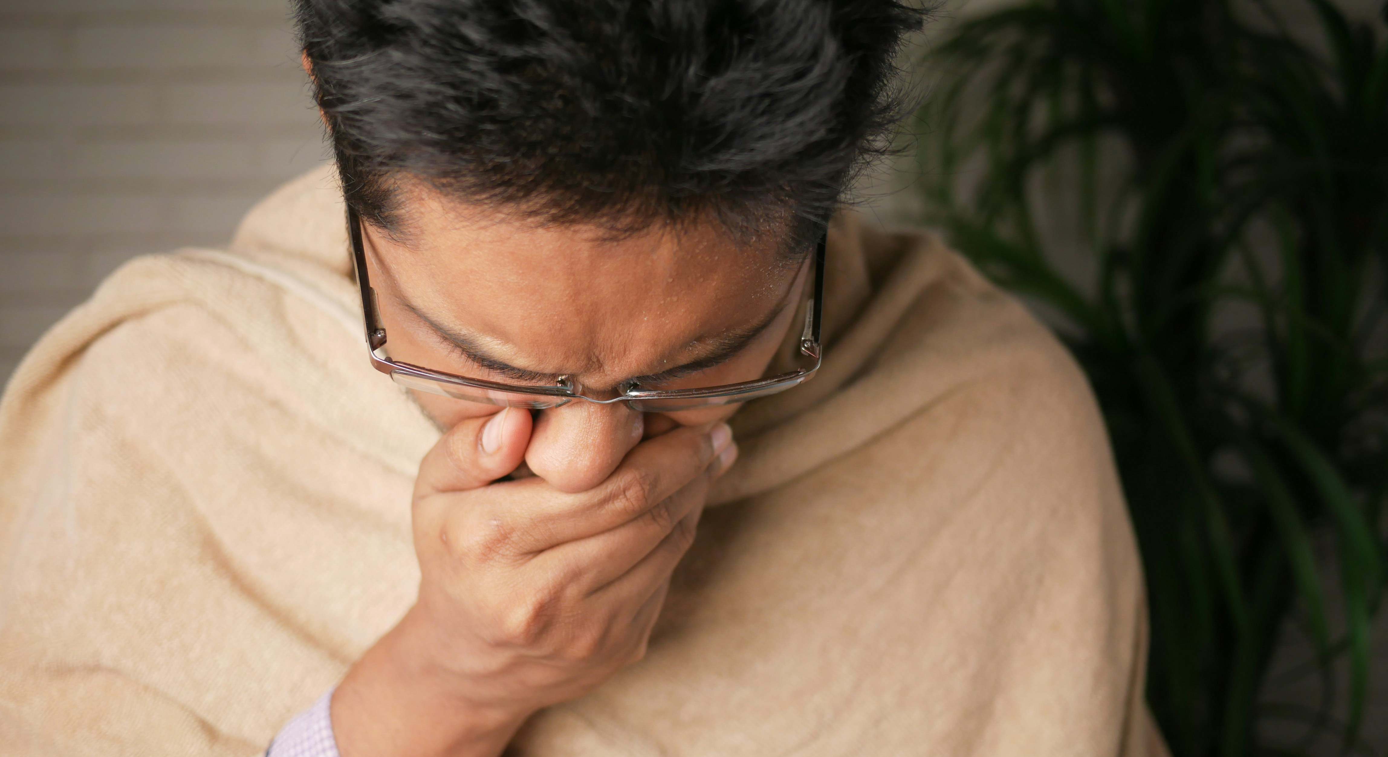 Una persona con alergia estornuda frente a la cámara