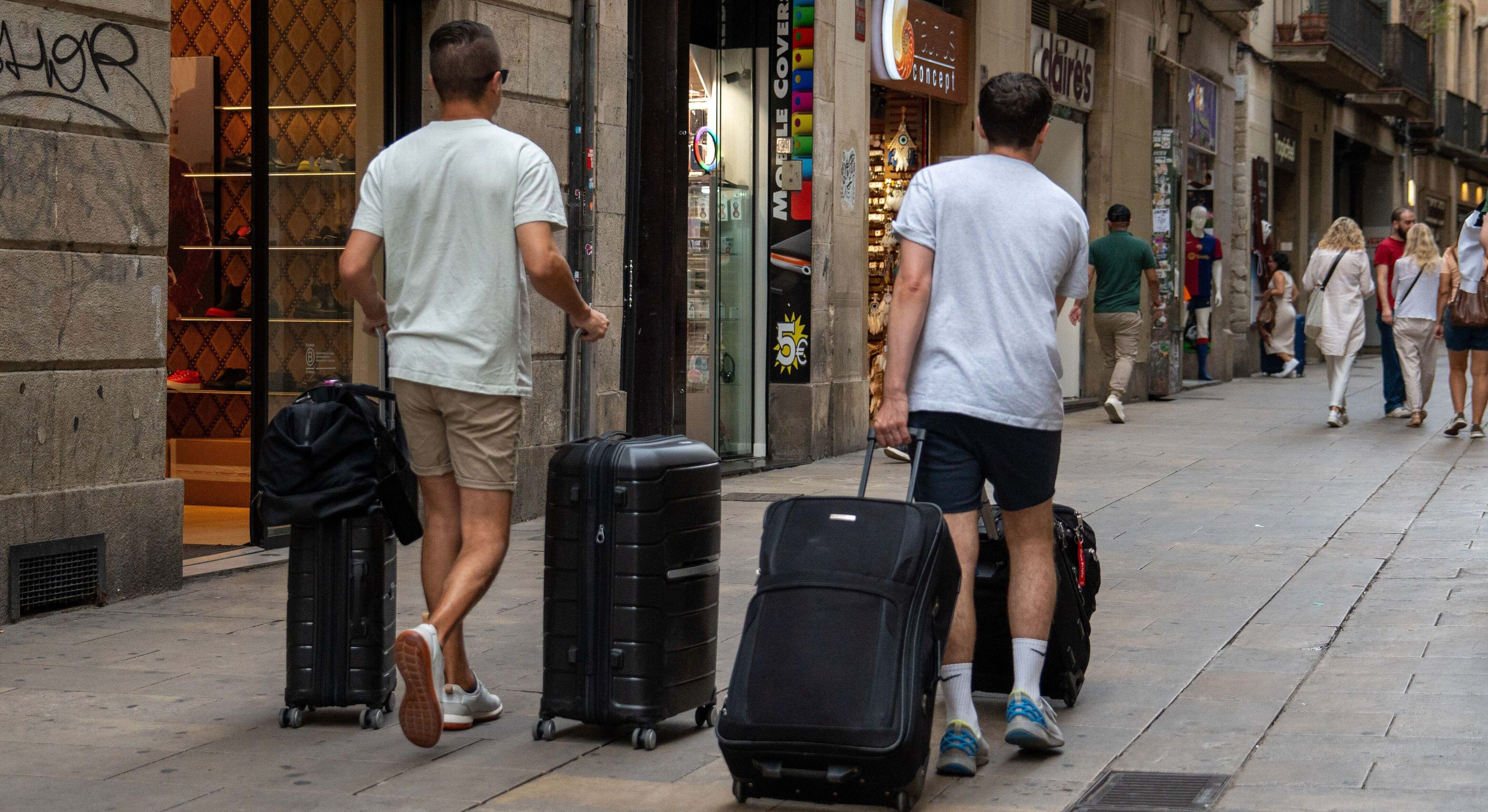 Turistas con maletas por la calle.
