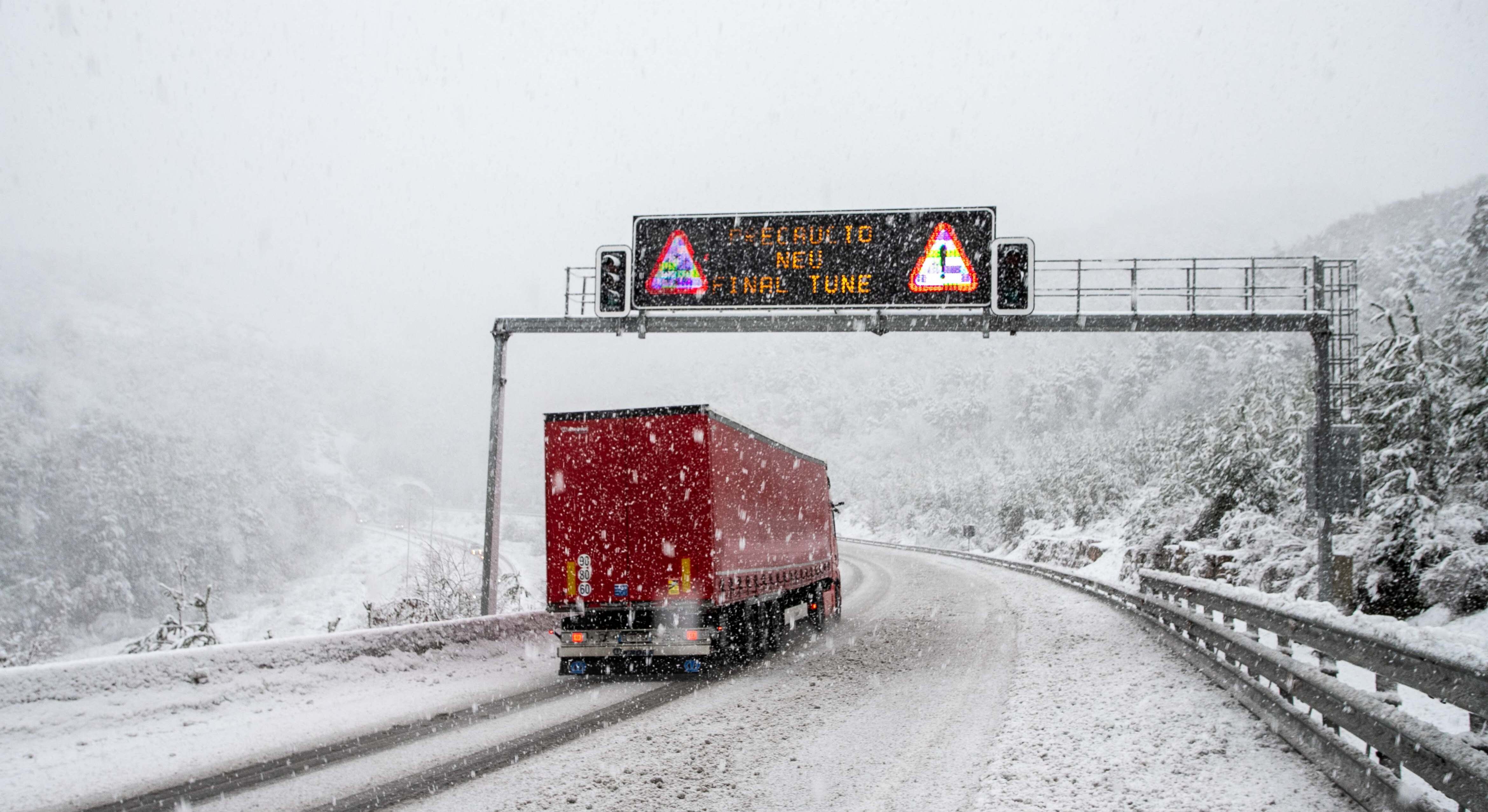 Un camión circulando durante una nevada