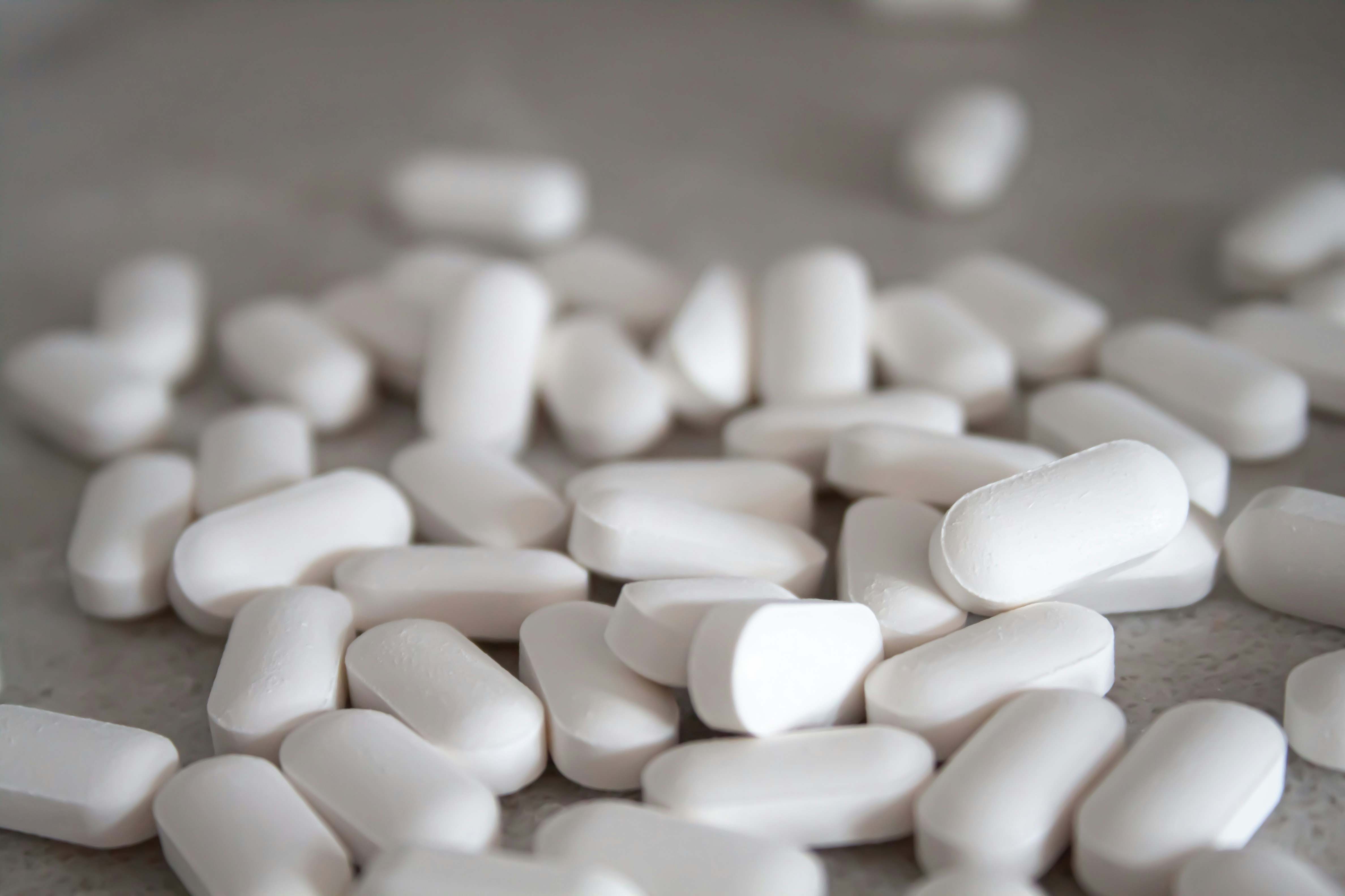 Varias pastillas juntas, sobre la mesa de una farmacia