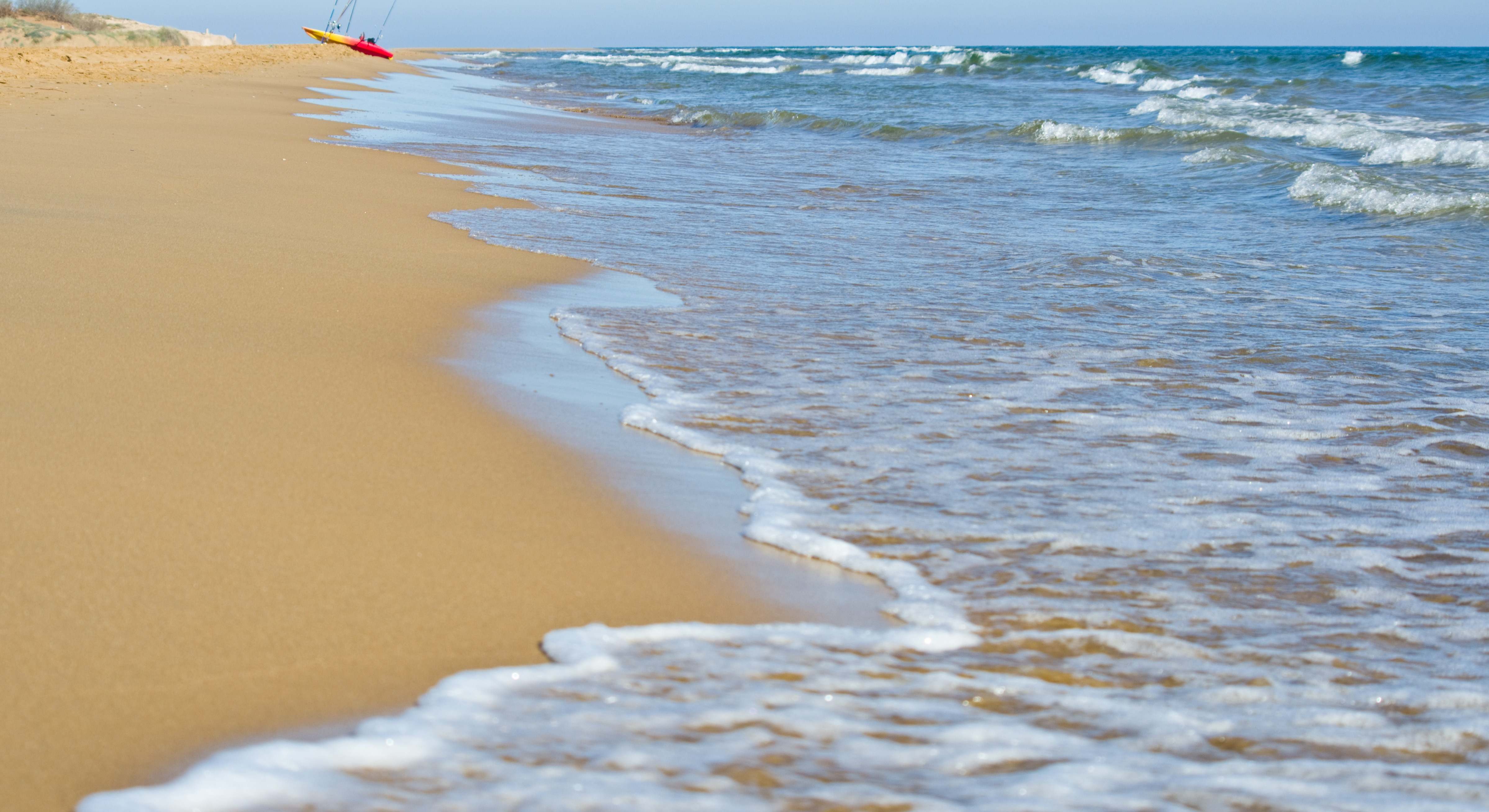 Playa de Murcia con una canoa de los colores de España al fondo