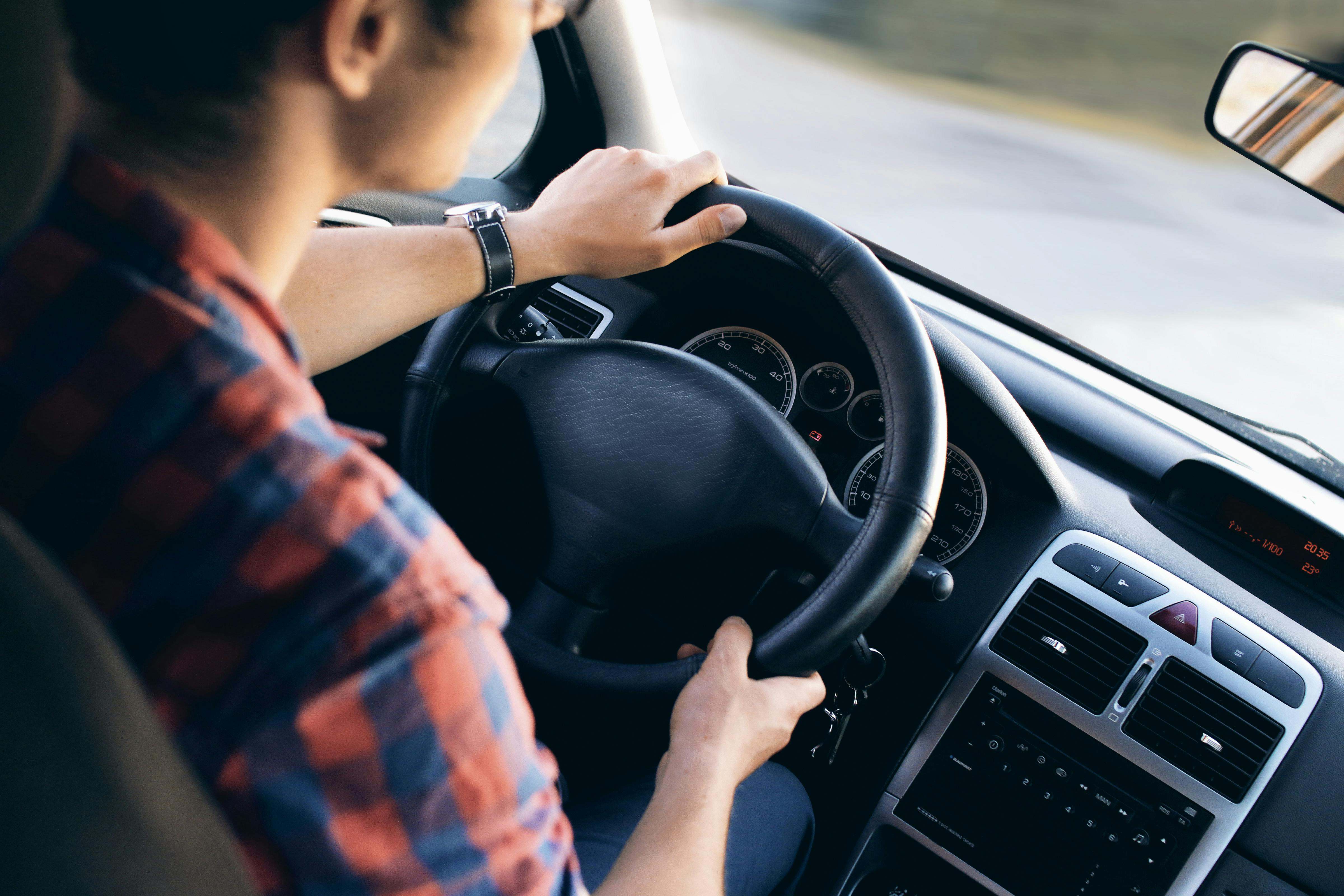 Una persona conduce su coche mientras mira por el retrovisor