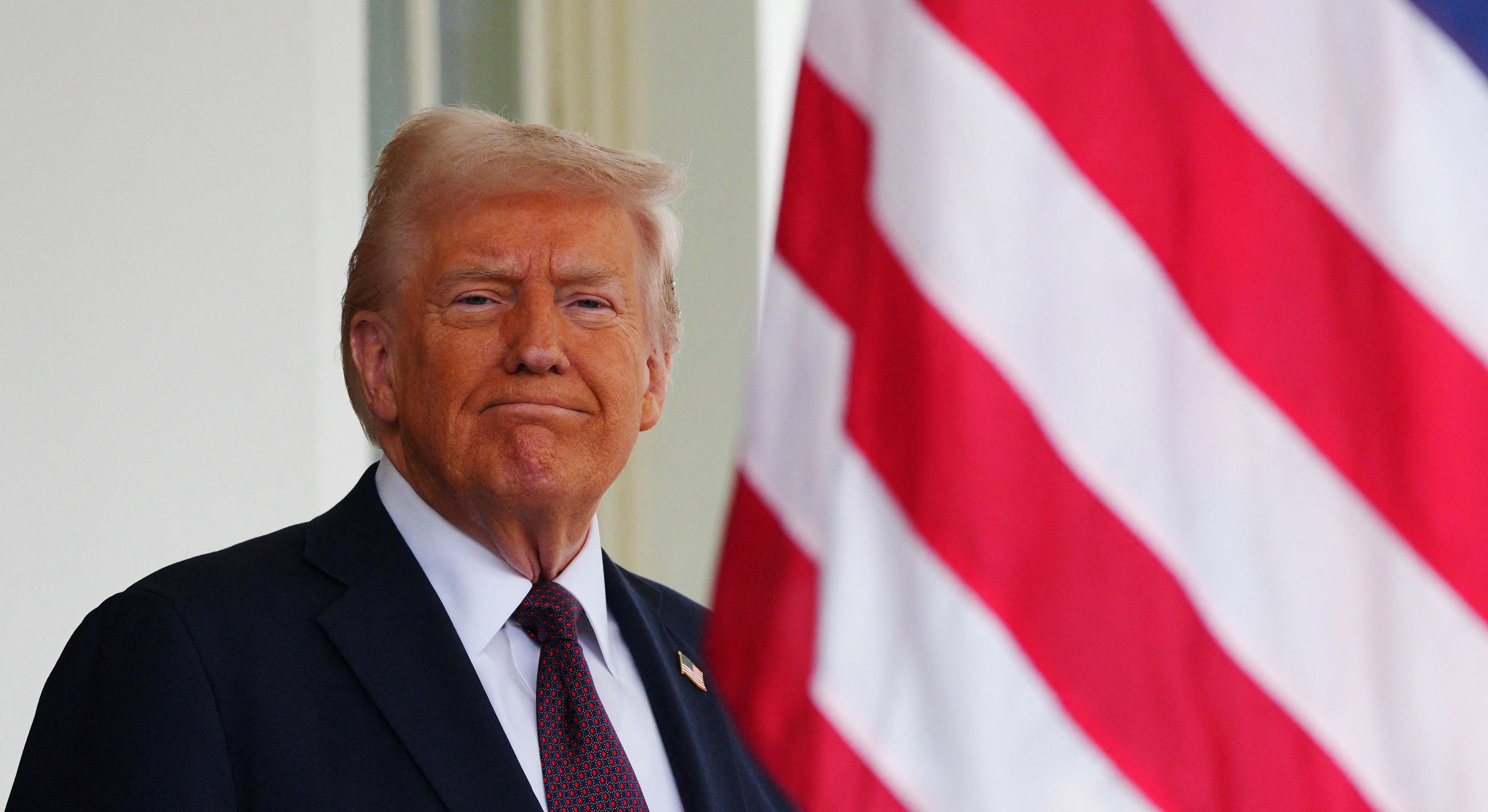 Donald Trump delante de una bandera de EEUU