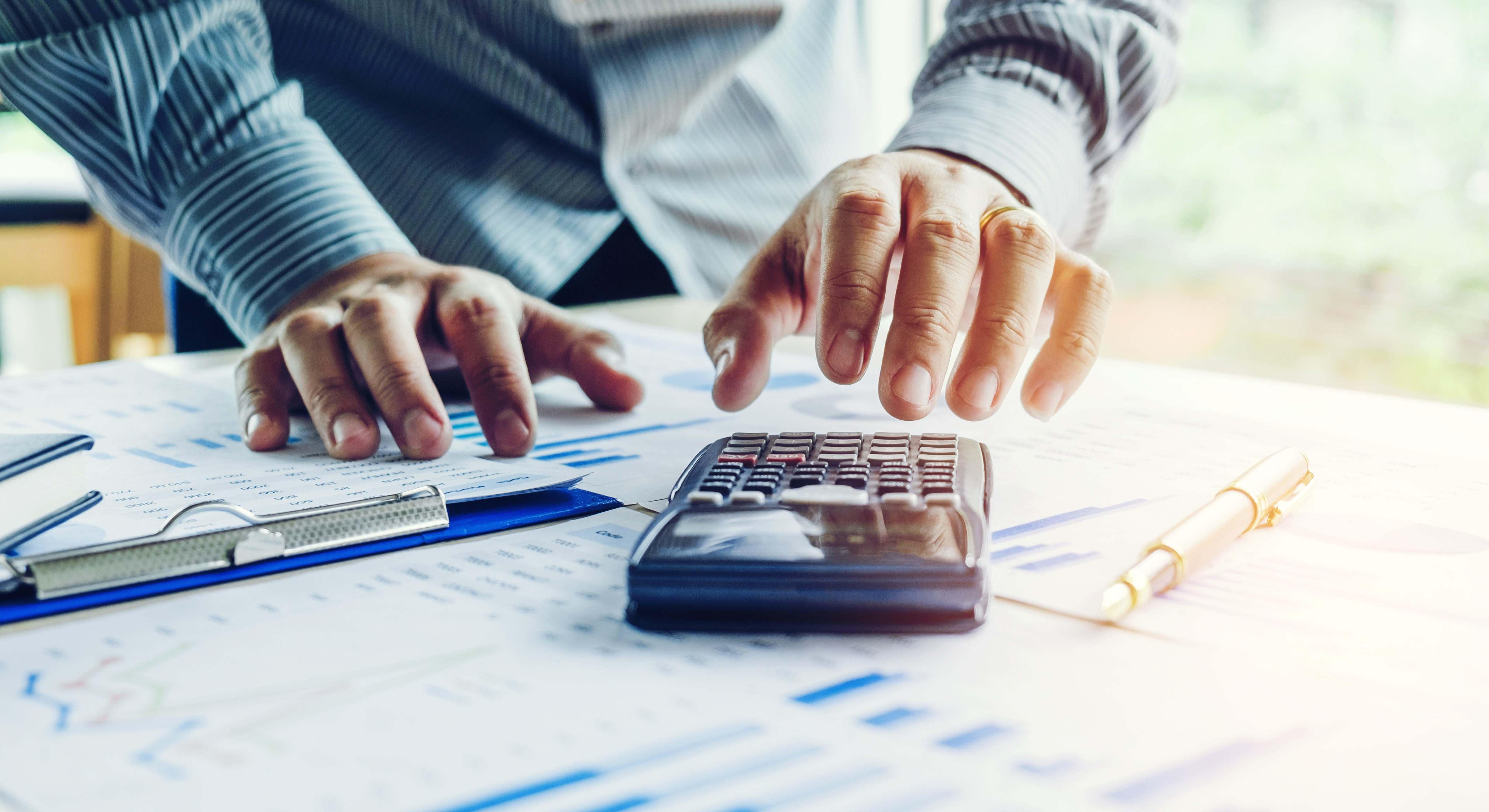 Una persona hace cuentas con una calculadora