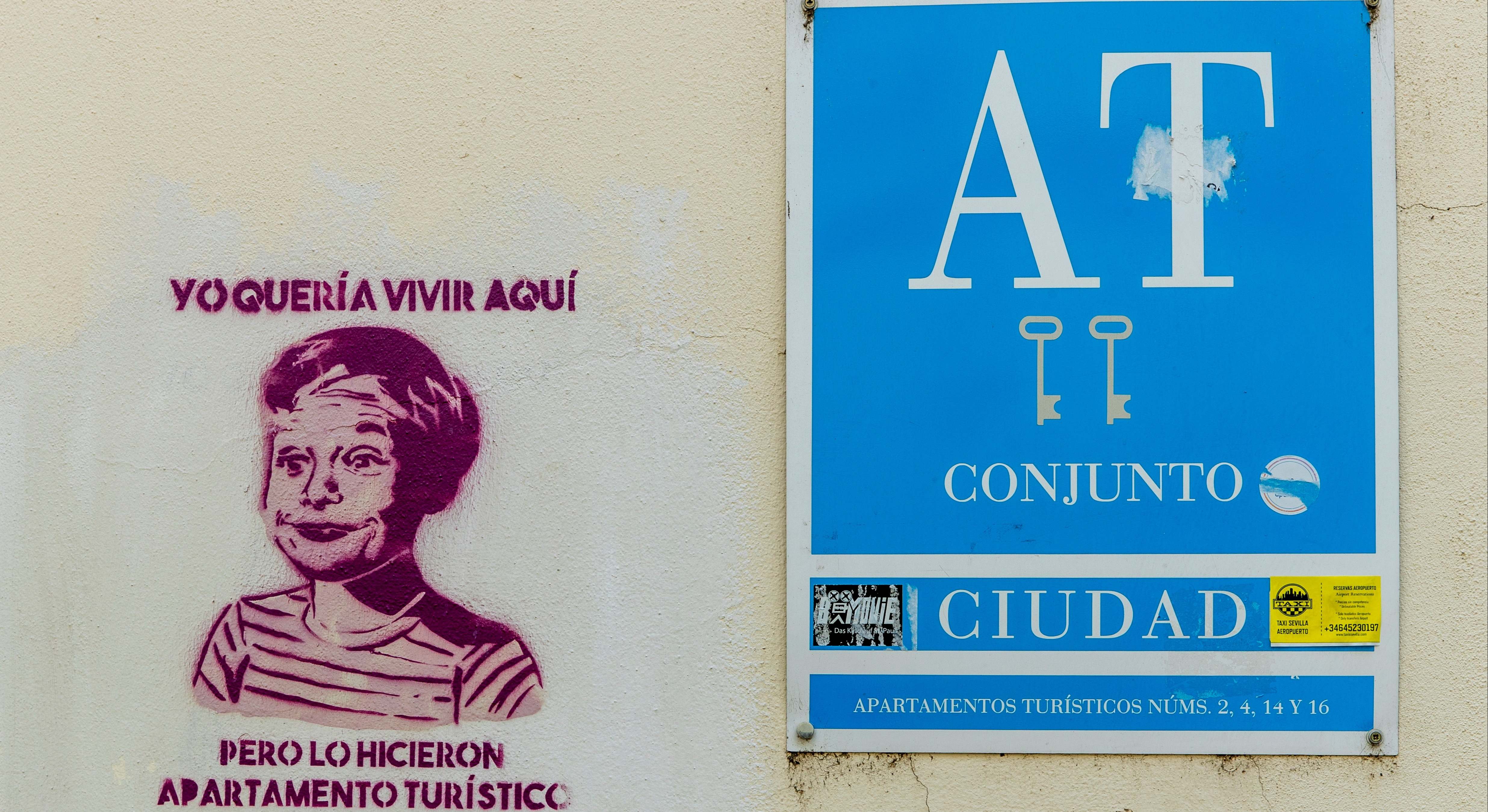 Cartel de piso turístico y pintada de protesta al lado. Foto: Efe