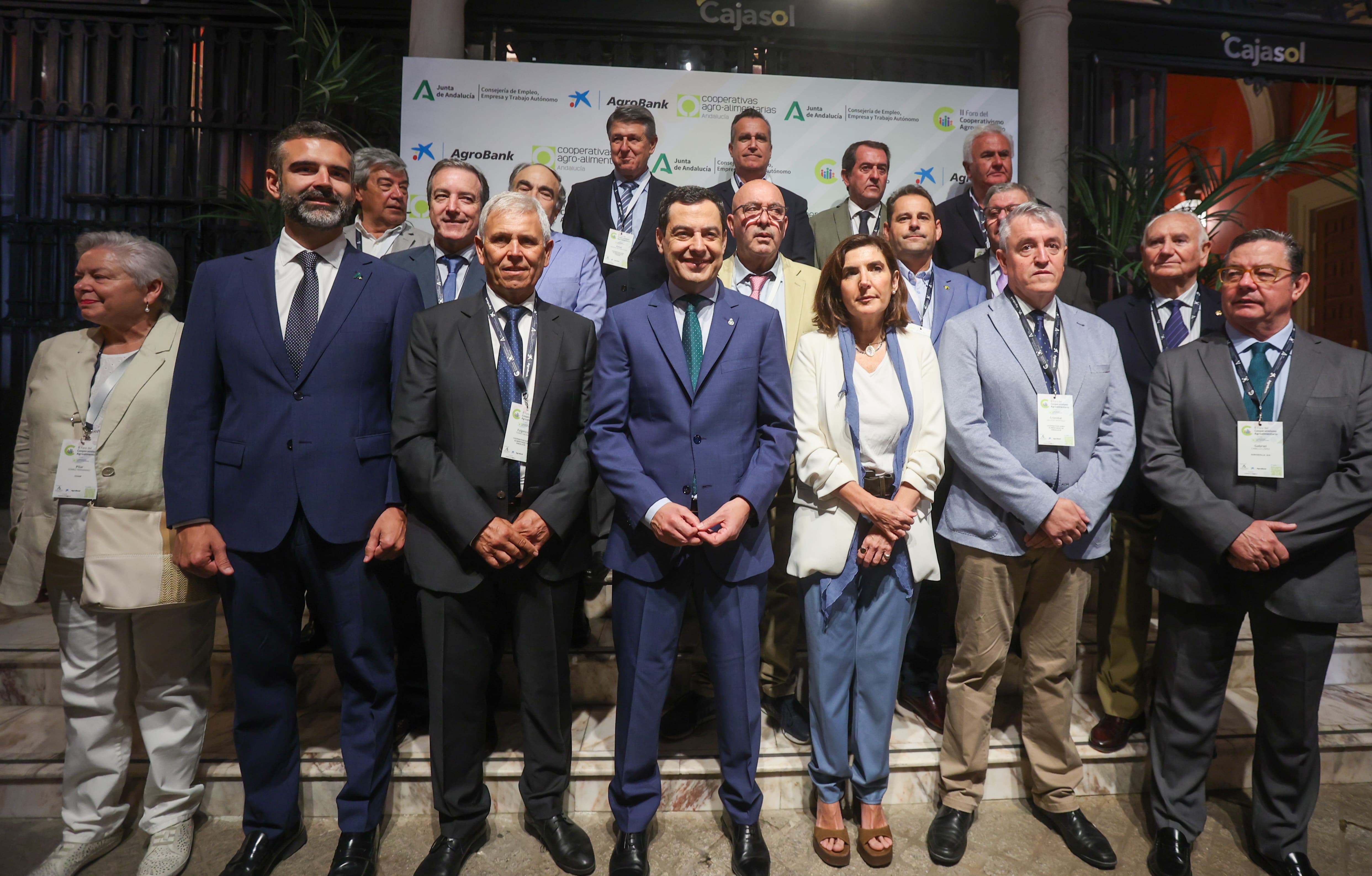 El presidente Juanma Moreno posa con el presidente de Cooperativas Agro-alimentarias de Andalucía y su consejo rector, y con los consejeros de Empleo y Agricultura.