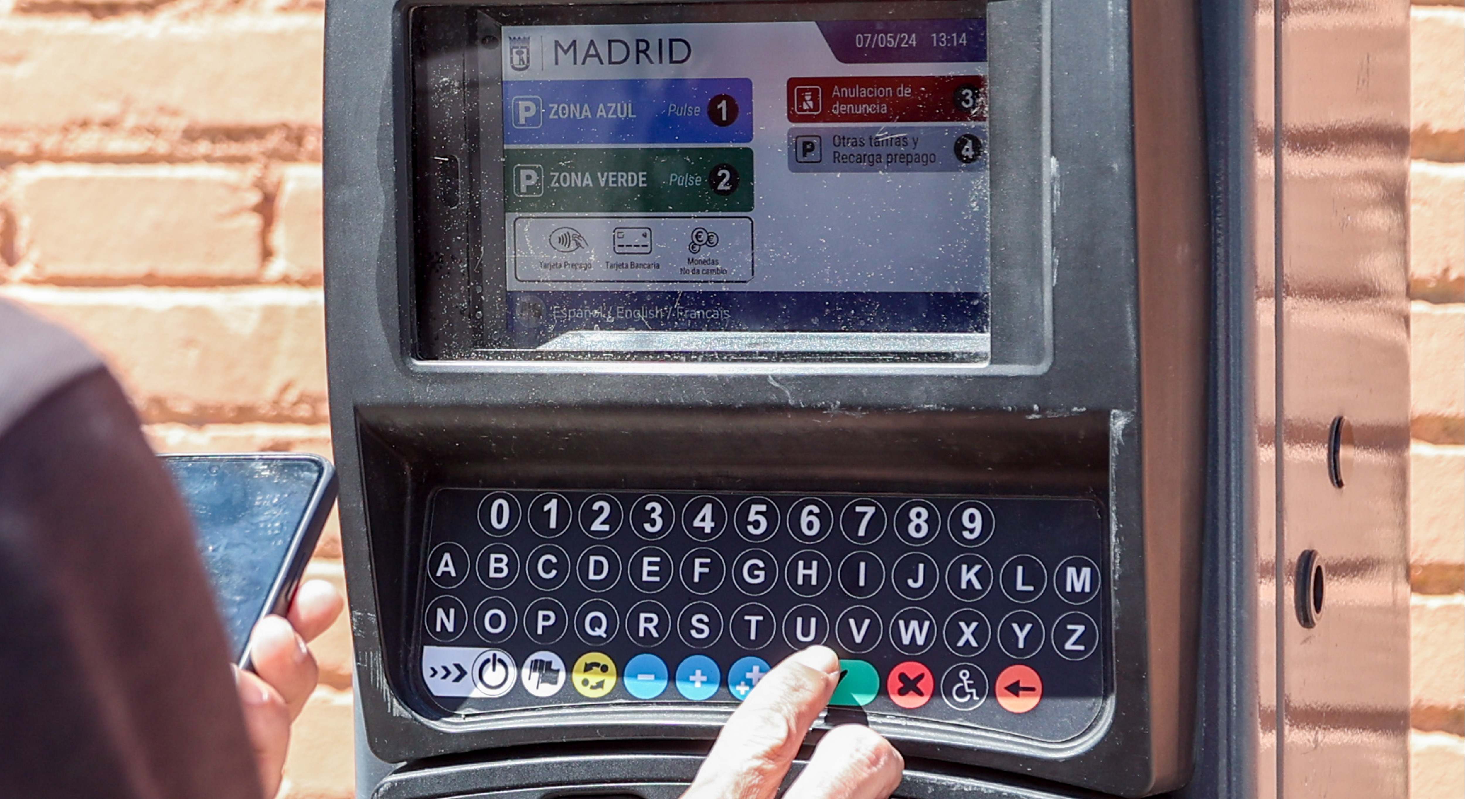 Una persona utiliza un parquímetro, a 7 de mayo de 2024, en Madrid. / Ricardo Rubio (Europa Press)
