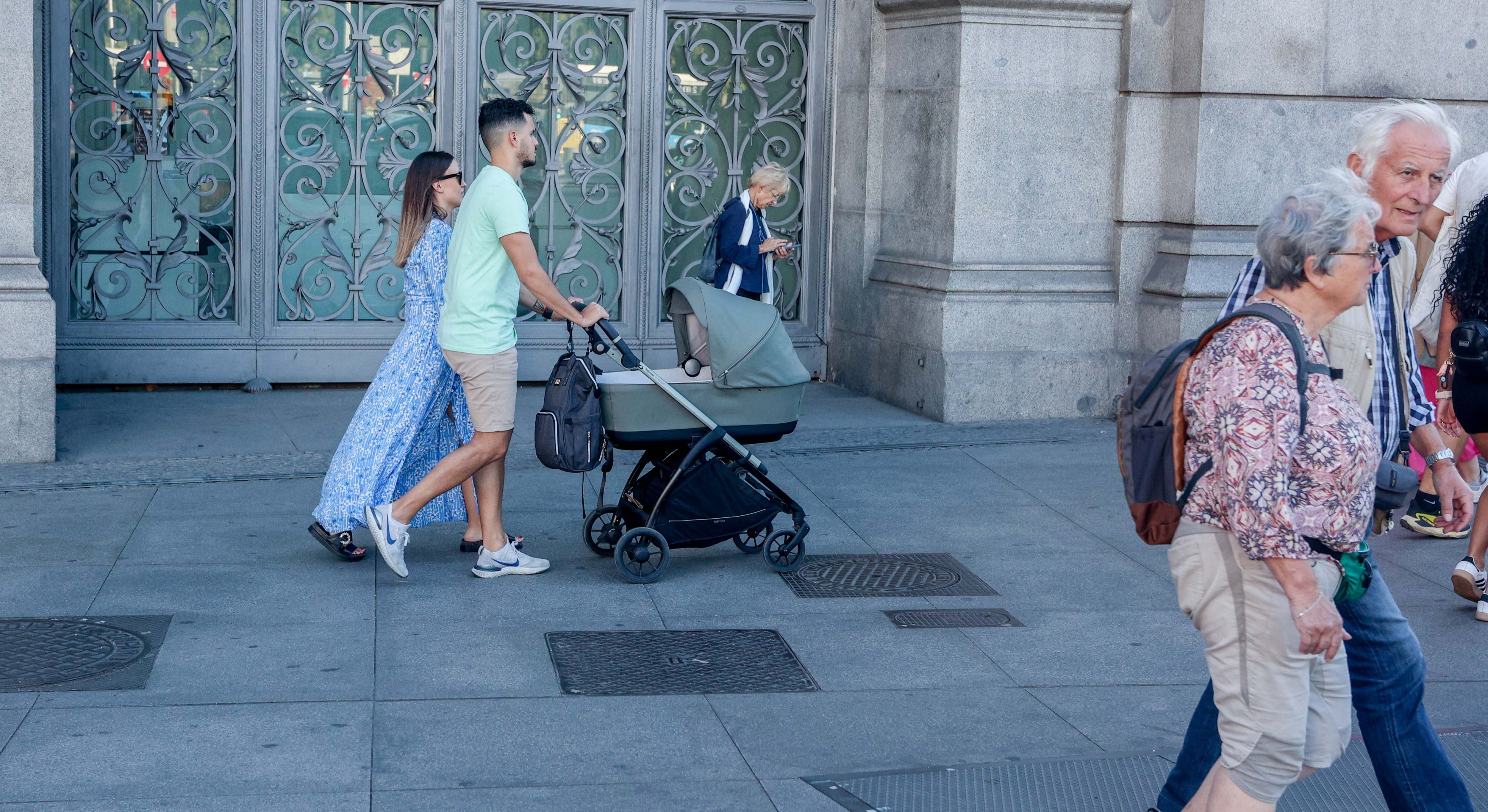 Imagen de recurso de una pareja paseando con un carrito de bebé.