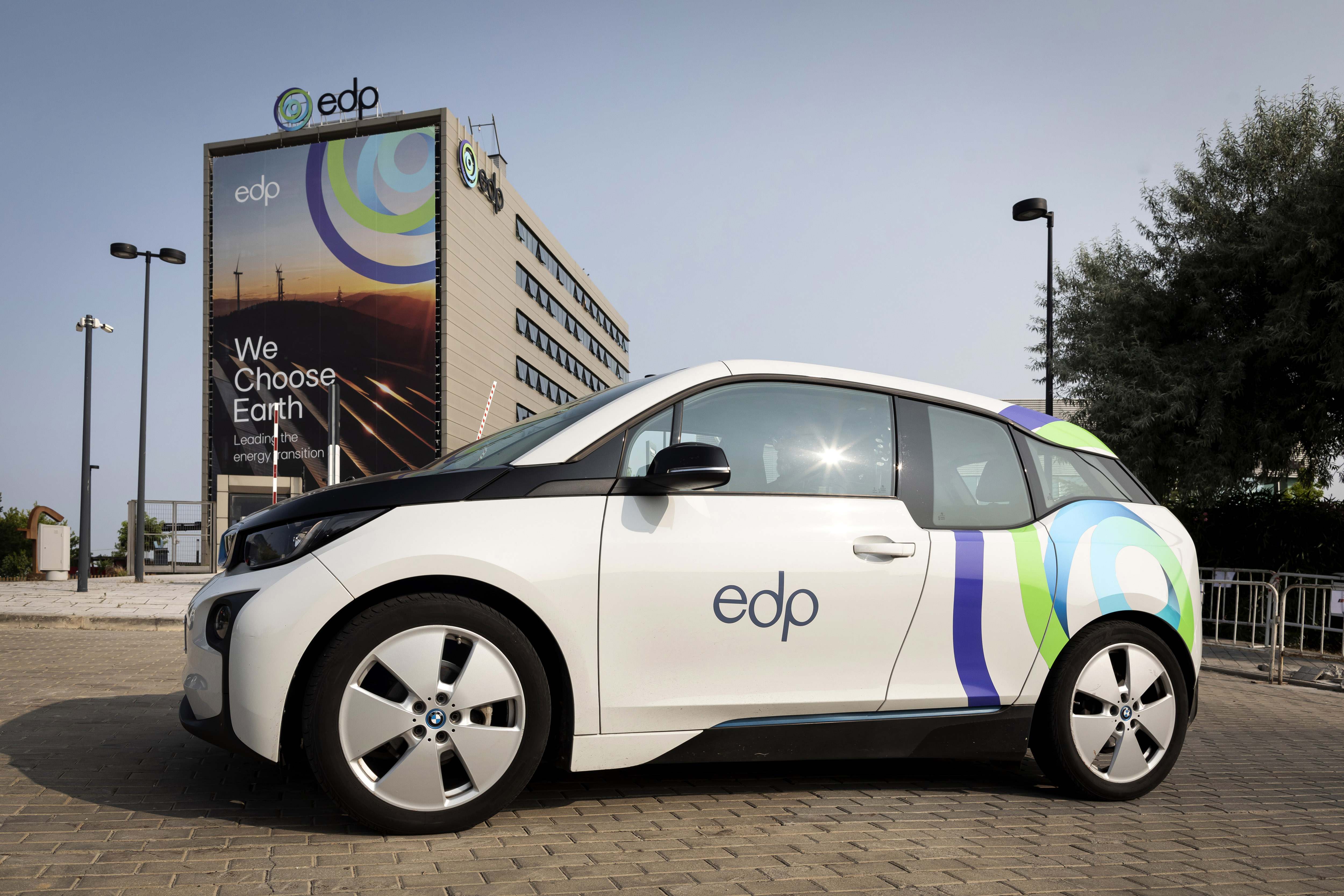 Coche blanco con el logo de EDP frente a las oficinas de EDP
