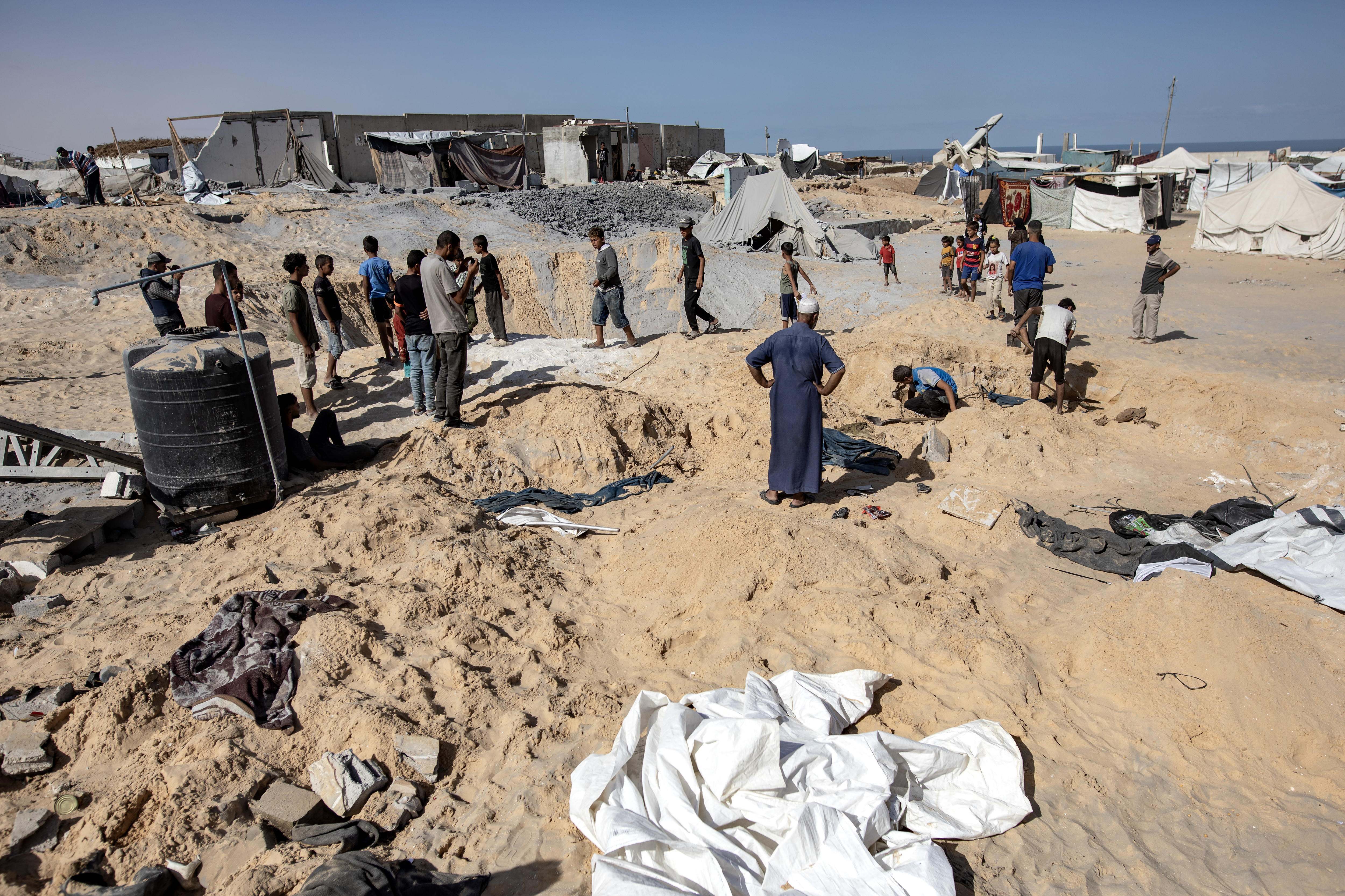 Desplazados internos palestinos evalúan los daños en sus tiendas después de un ataque israelí en Gaza, mientras el conflicto ha causado más de 42,000 muertes desde octubre de 2023.