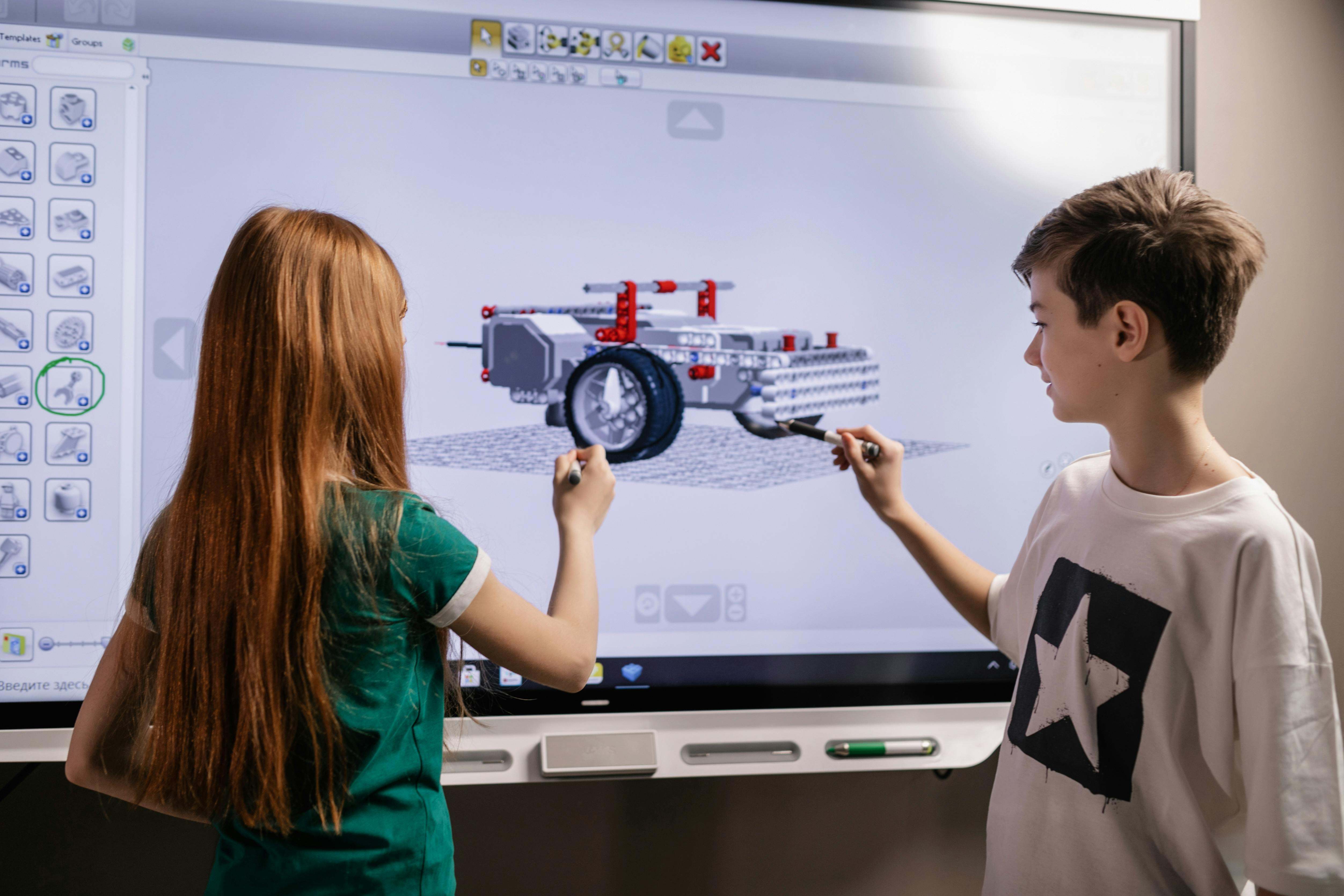Dos jóvenes utilizando en el aula una pantalla interactiva