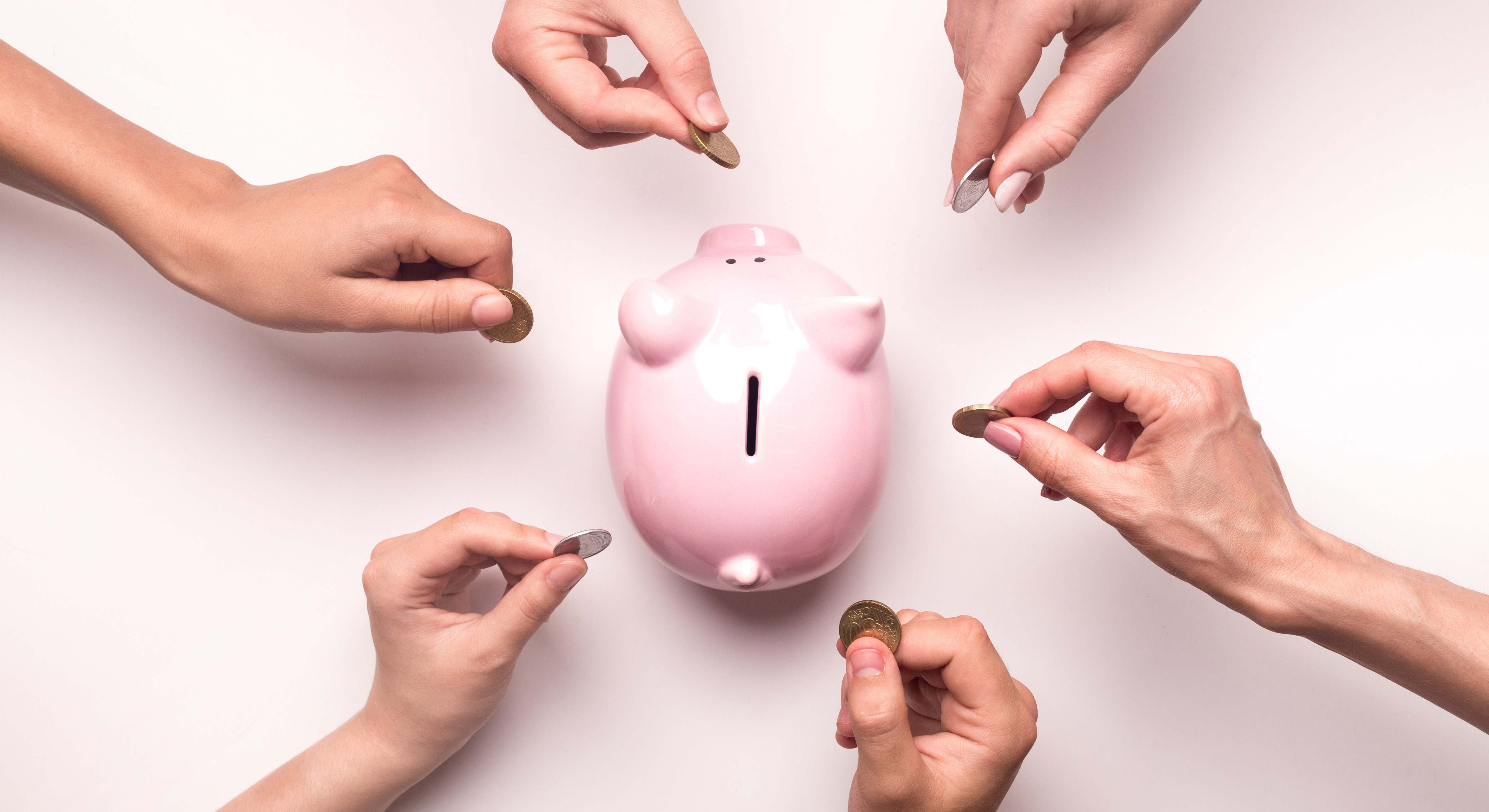 Varias personas meten dinero en una hucha