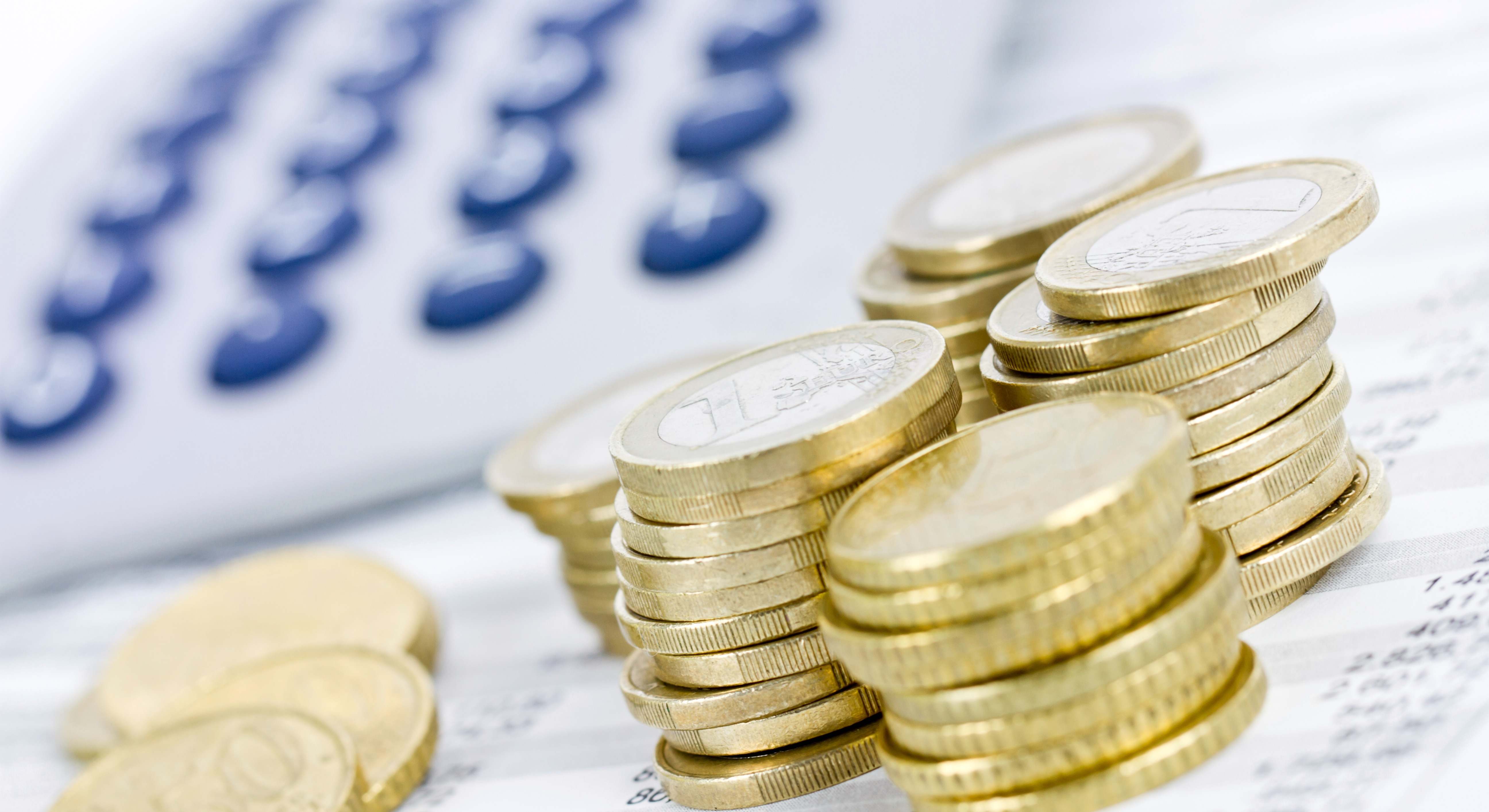 Varias monedas junto a una calculadora