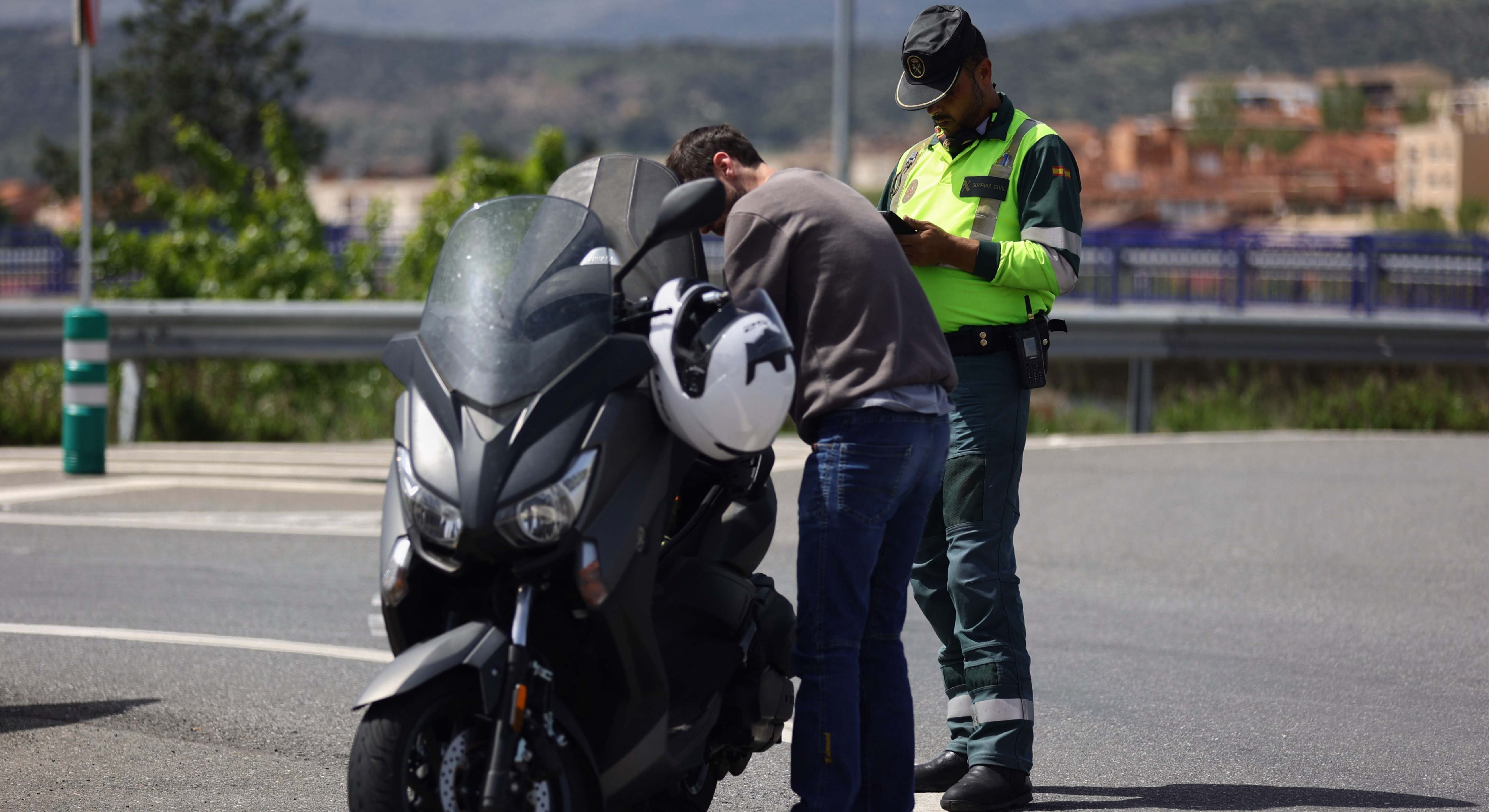 Un agente de la Guardia Civil para a una moto en un control de tráfico