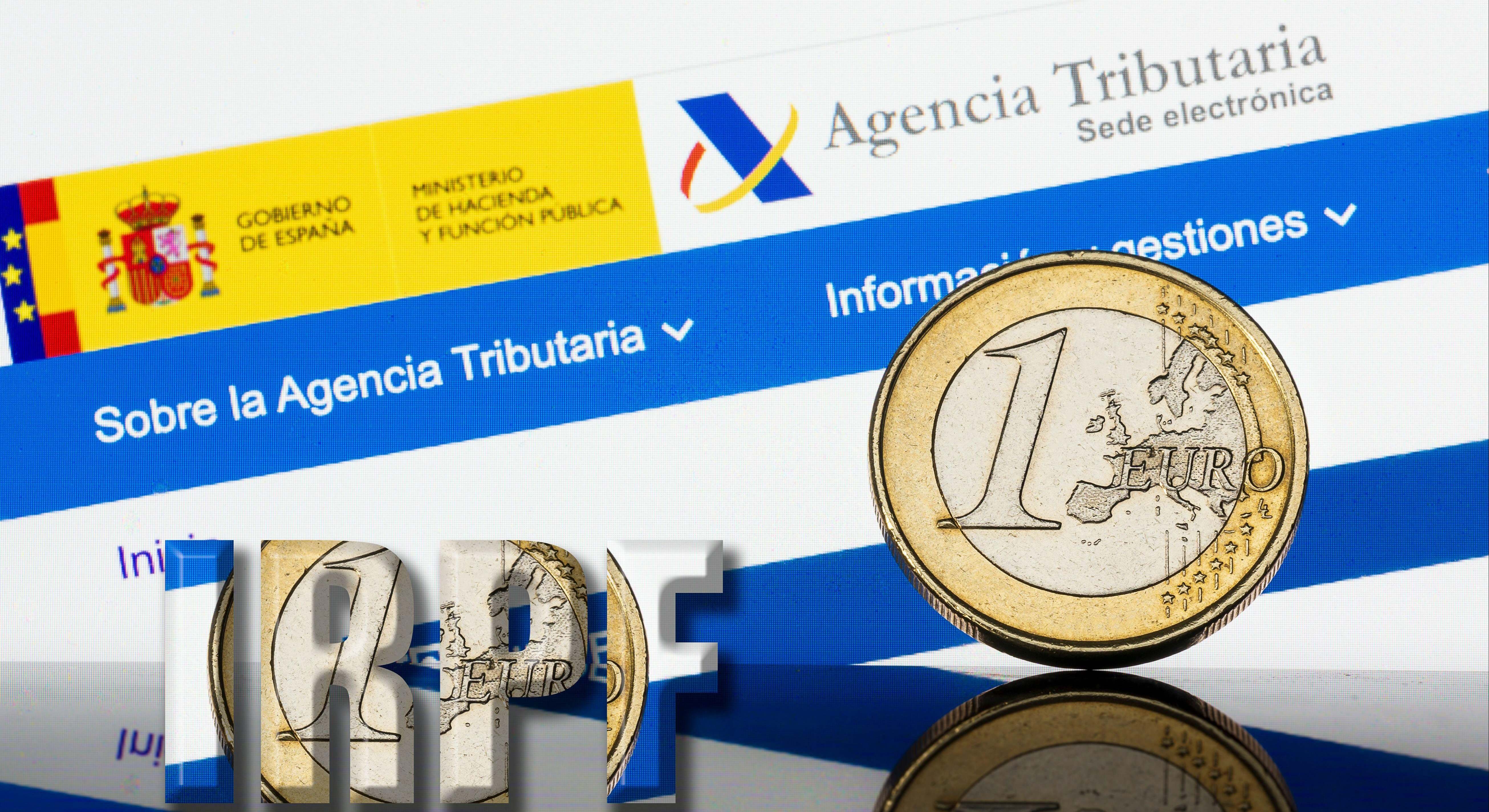 Una moneda de euro junto a la página web de la Agencia Tributaria