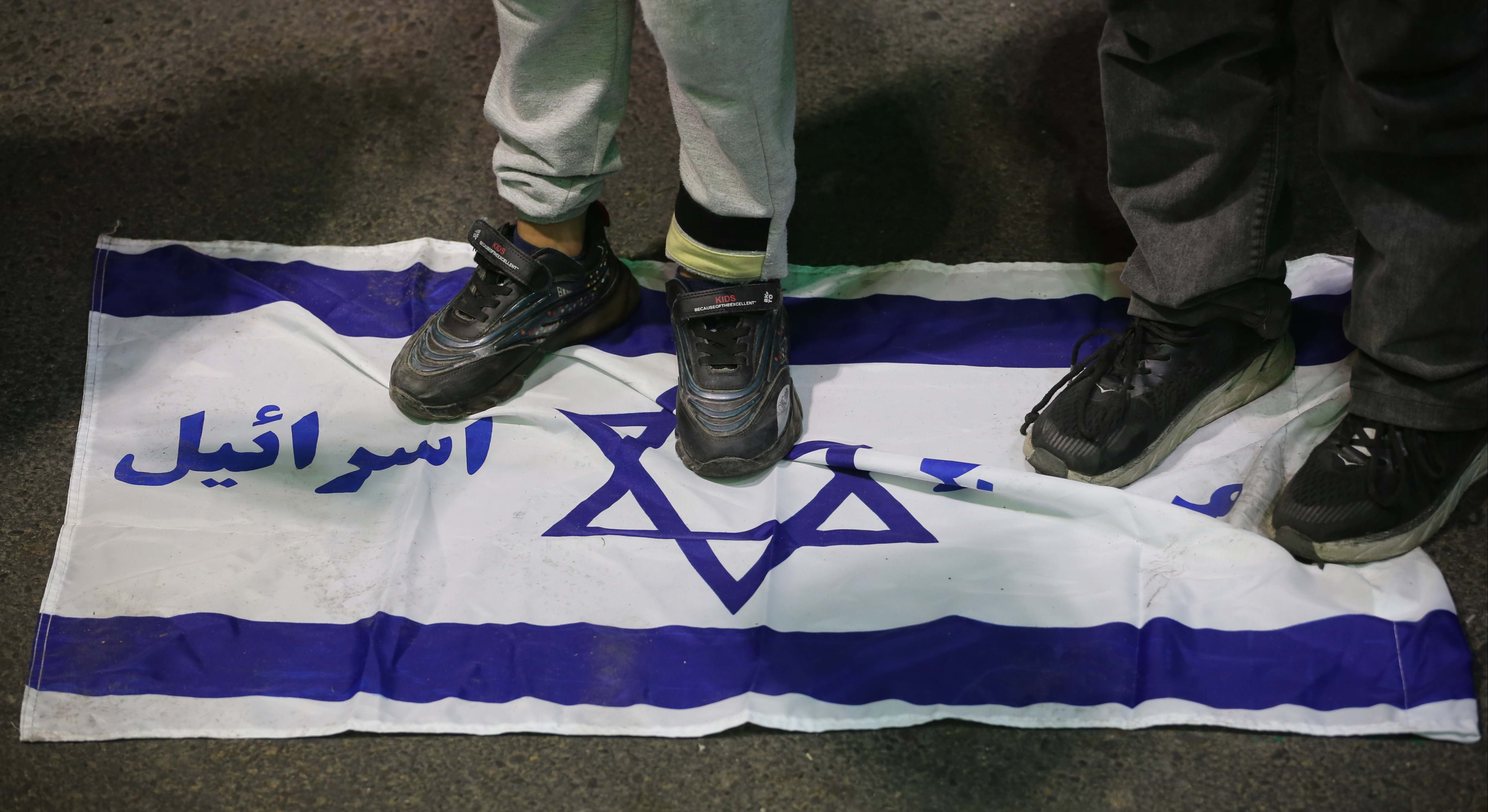Niños iraníes pisando una bandera de Israel en la Plaza de Palestina de Irán.