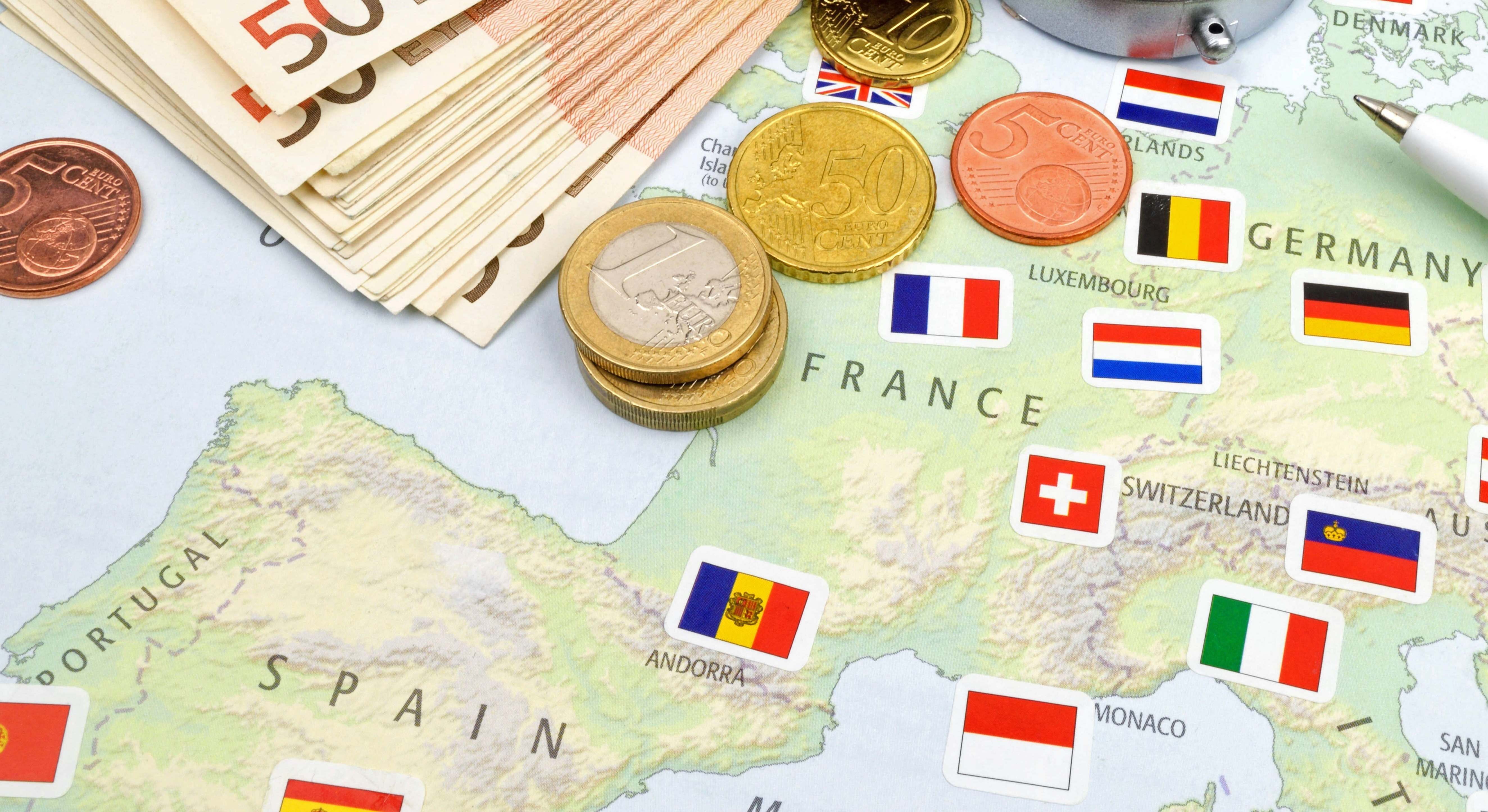 Un mapa de España junto a dinero y un pasaporte