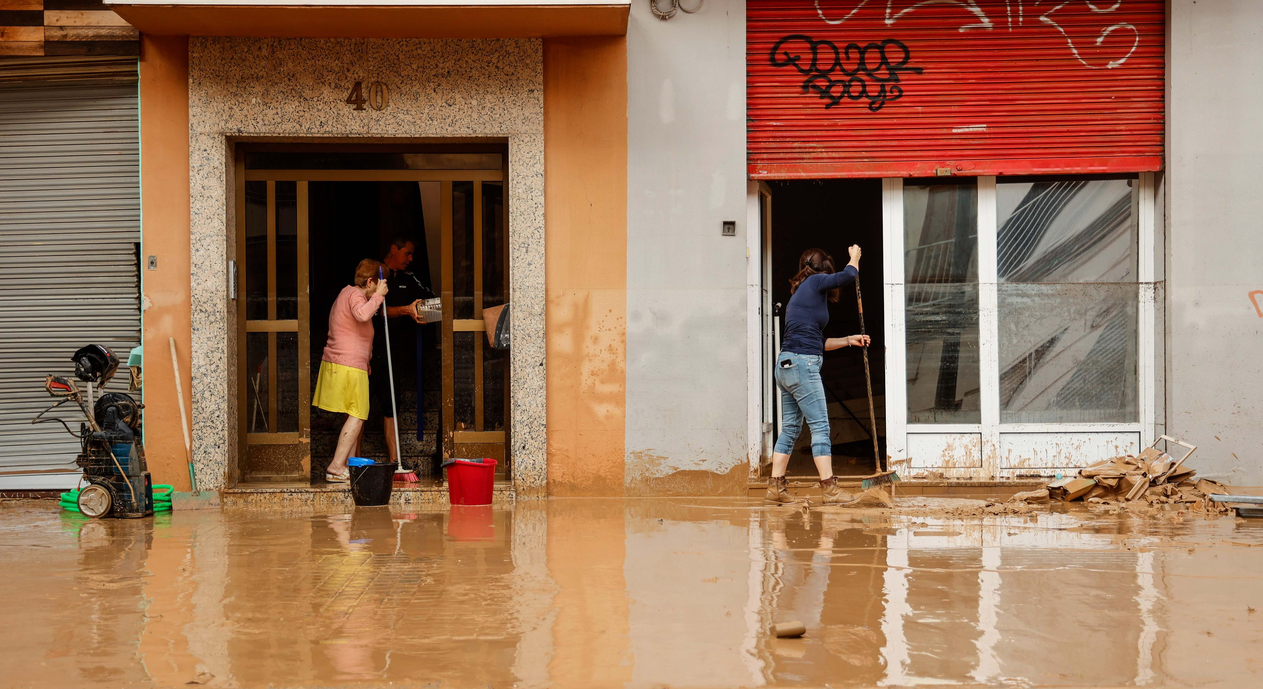 Varias personas realizan labores de limpieza tras el paso de la DANA por el barrio de La Torre de Valencia, a 30 de octubre de 2024, en Valencia