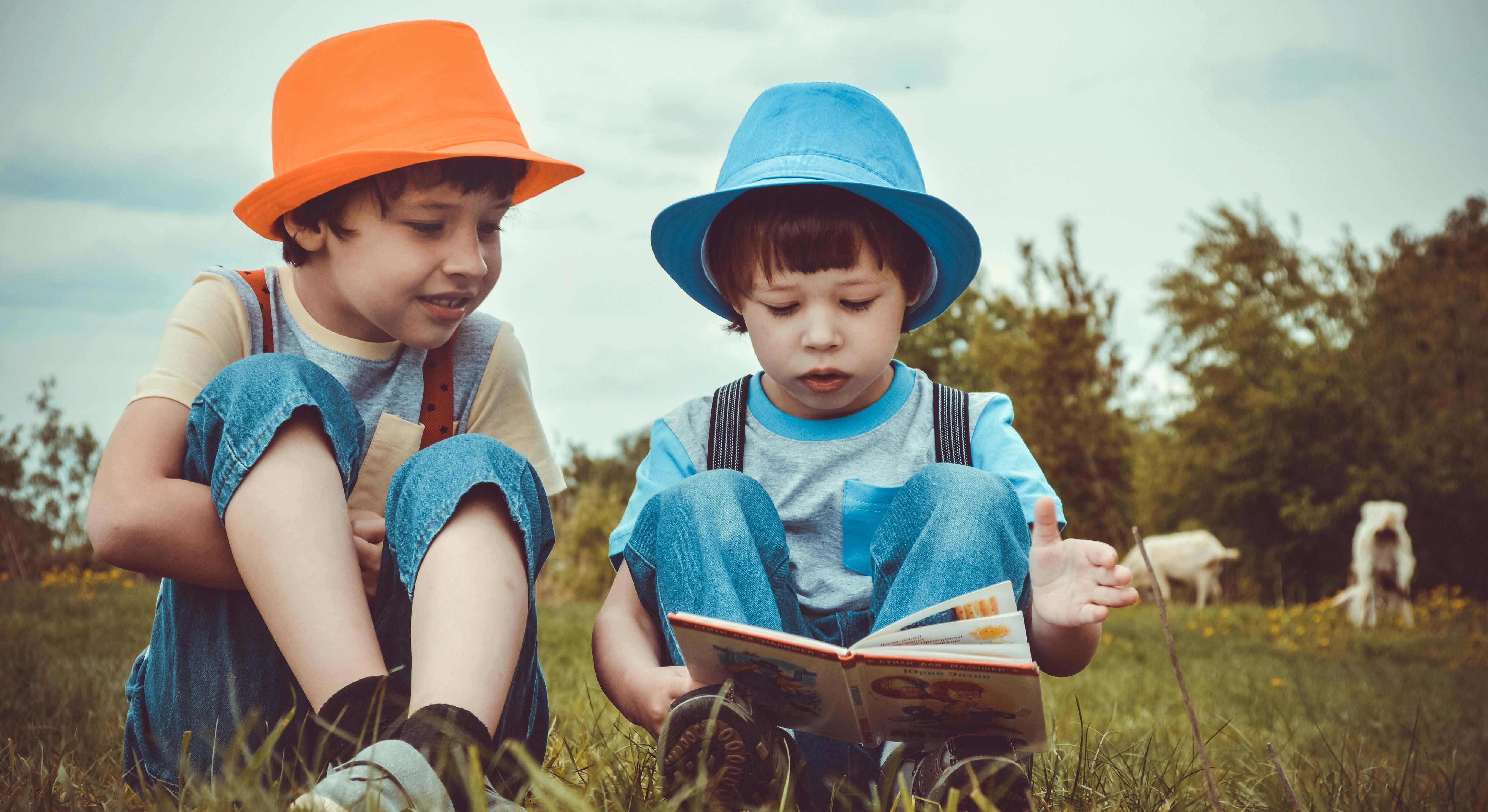 Niños leyendo sobre la hierba
