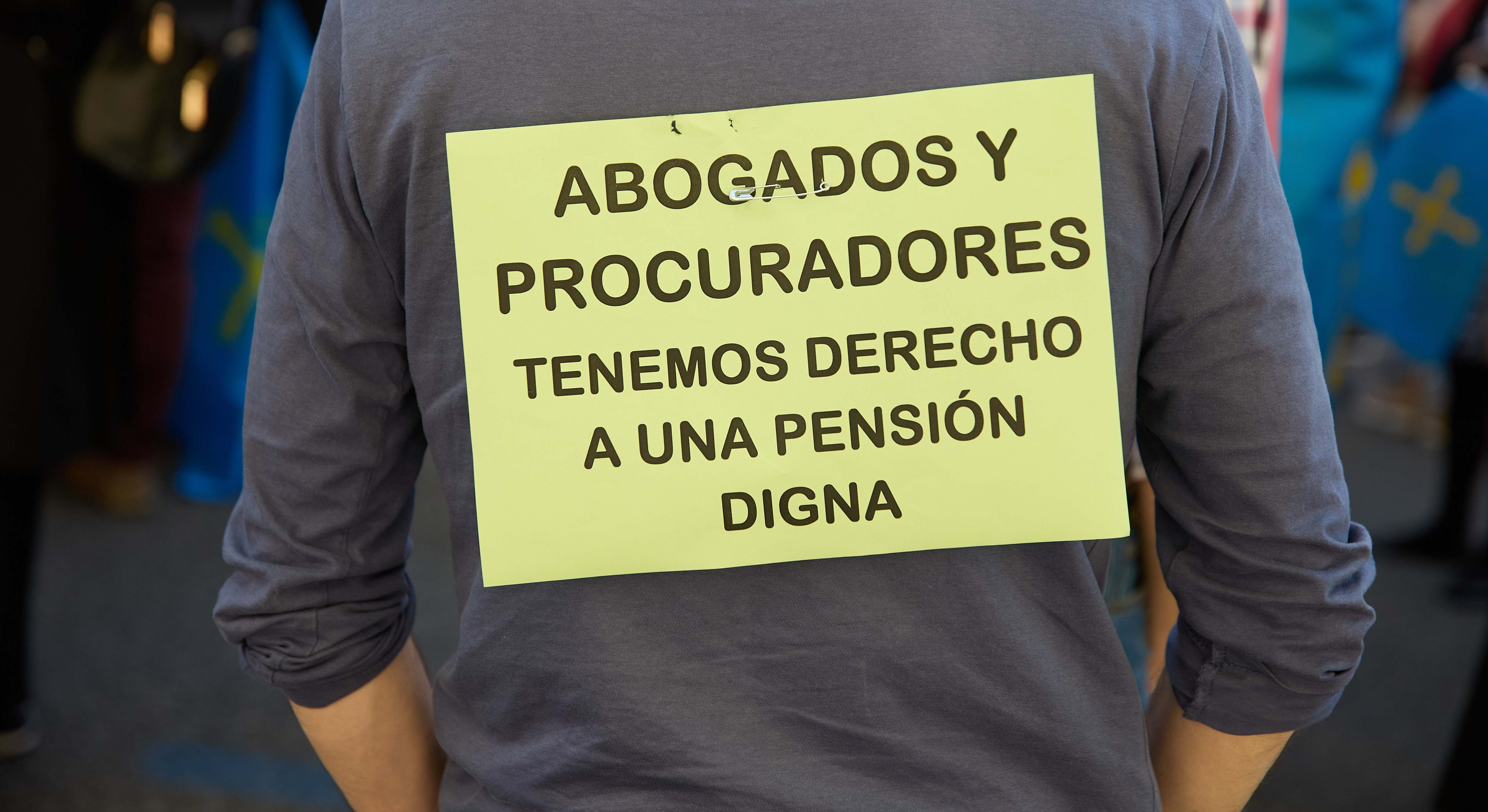 Una persona protesta para mejorar la pensión de abogados y procuradores