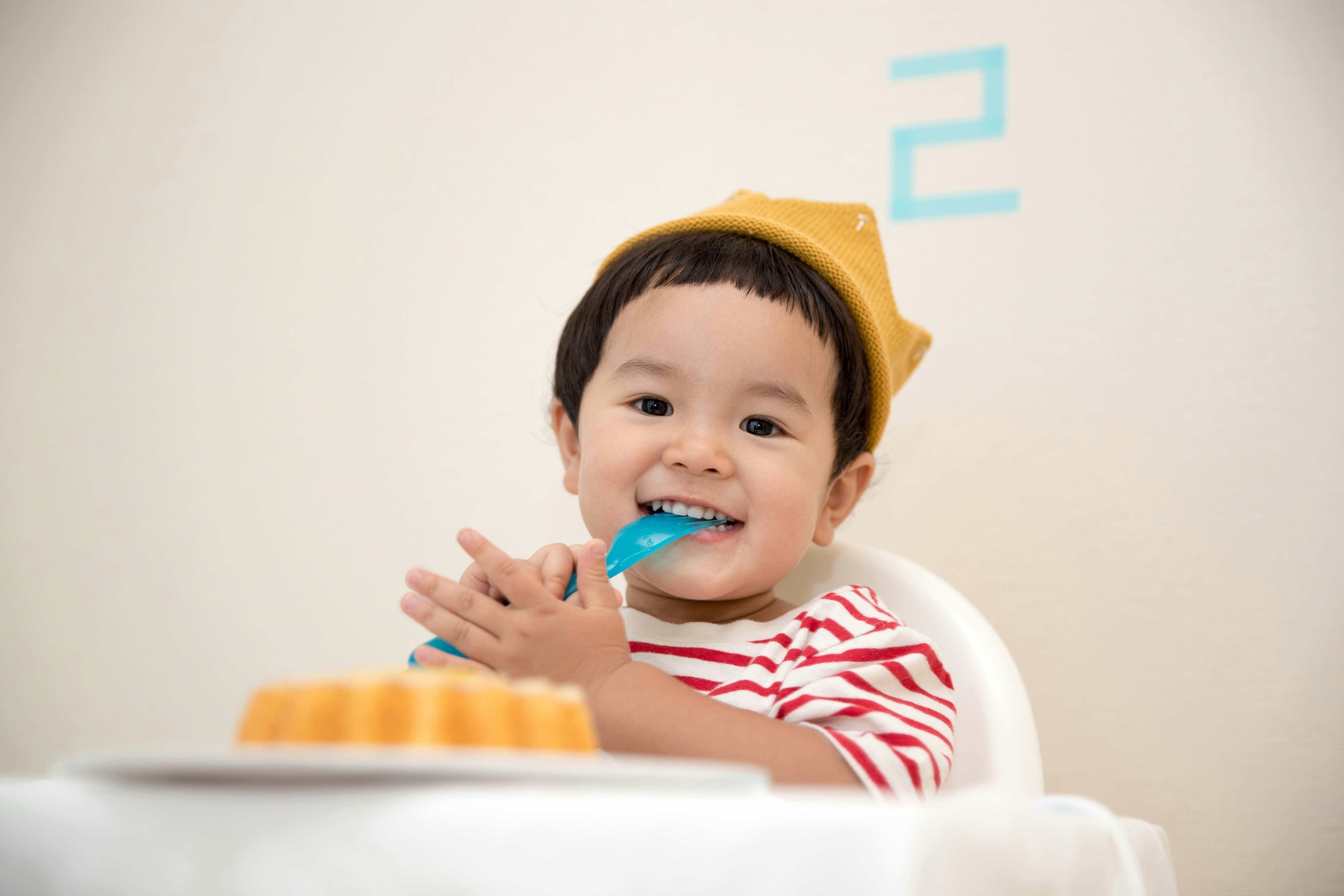 Un niño de dos años come un postre