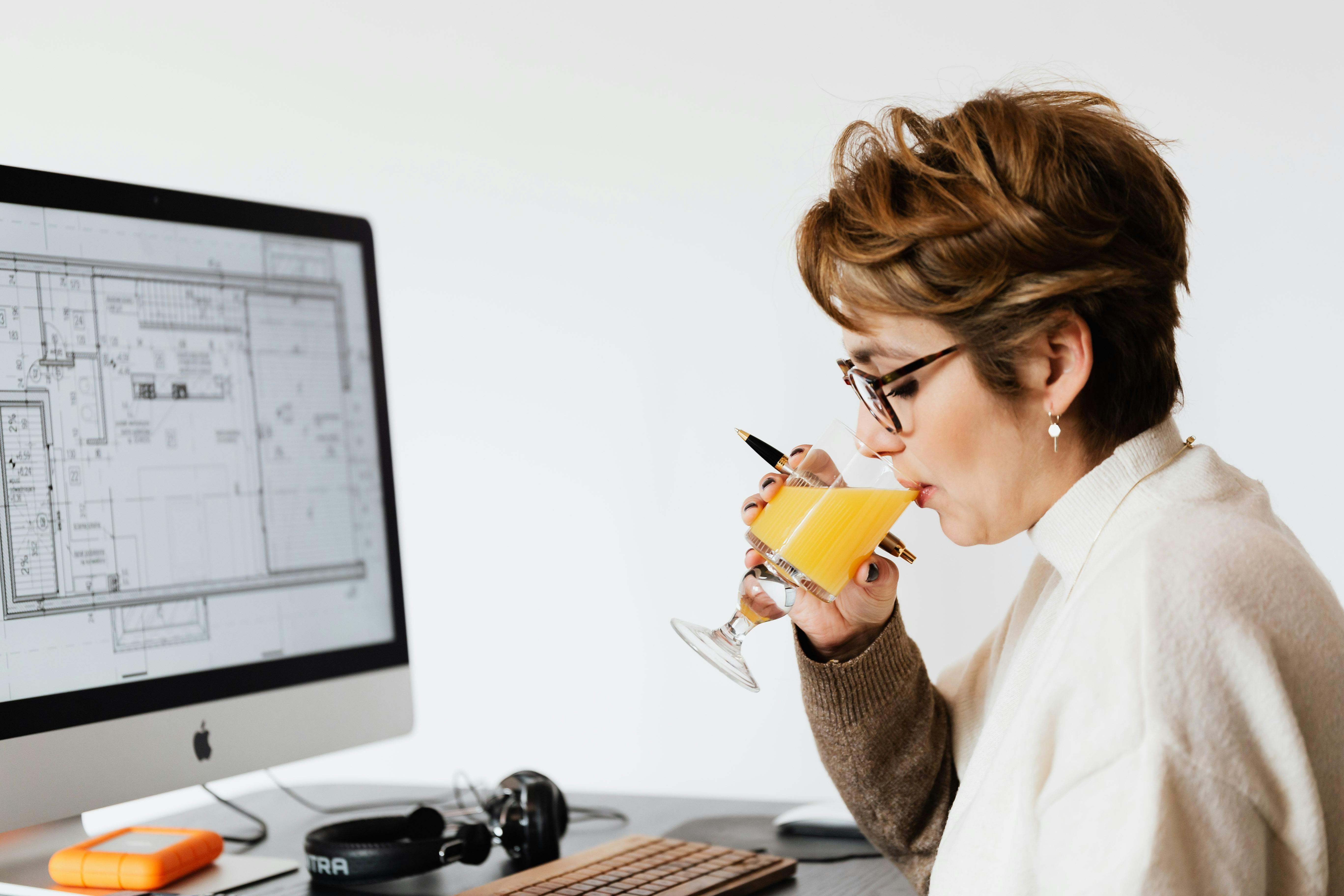 Una mujer bebe un zumo de naranja, rico en vitamina C