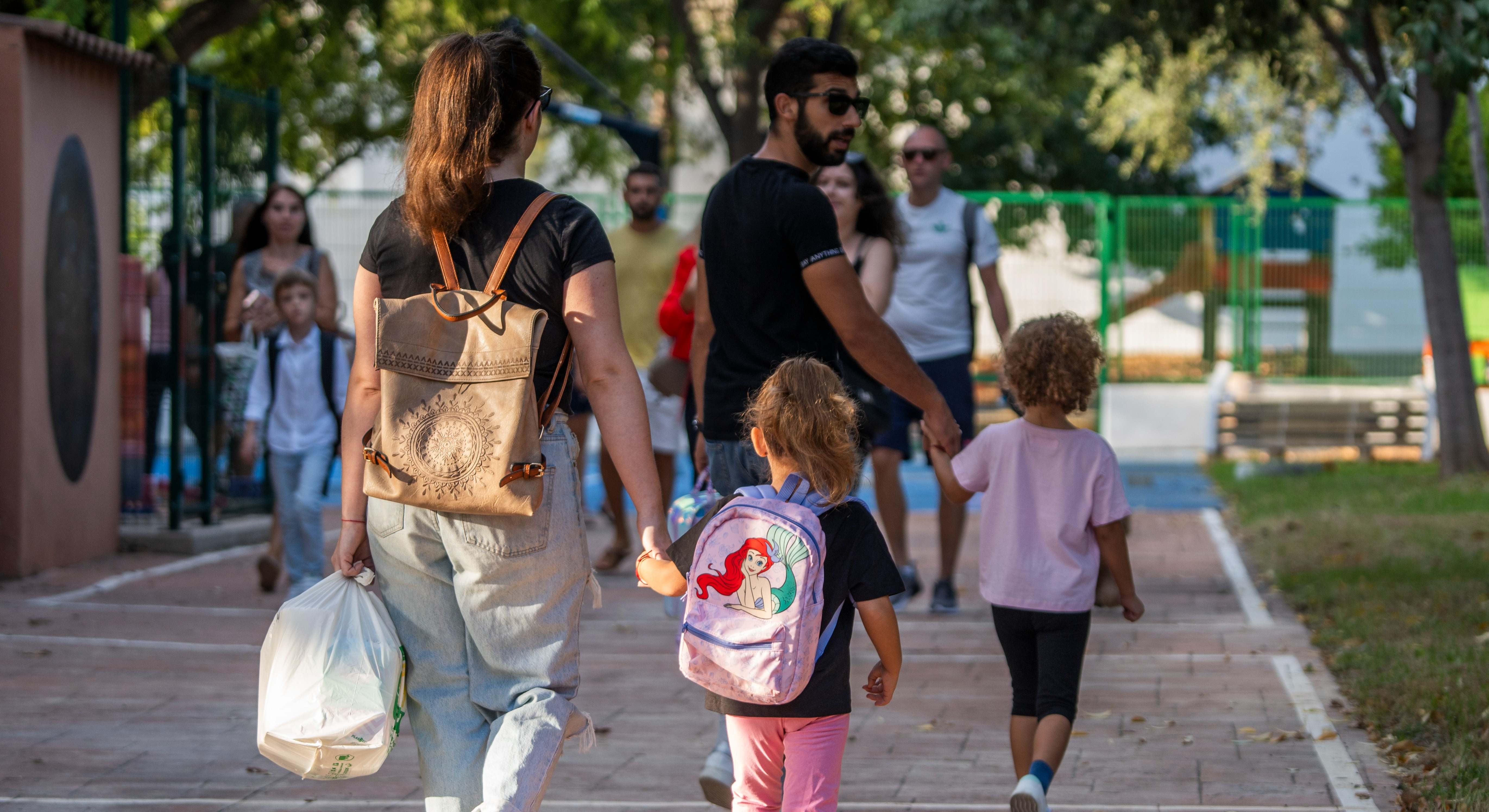Varios padres llevan a los niños al colegio