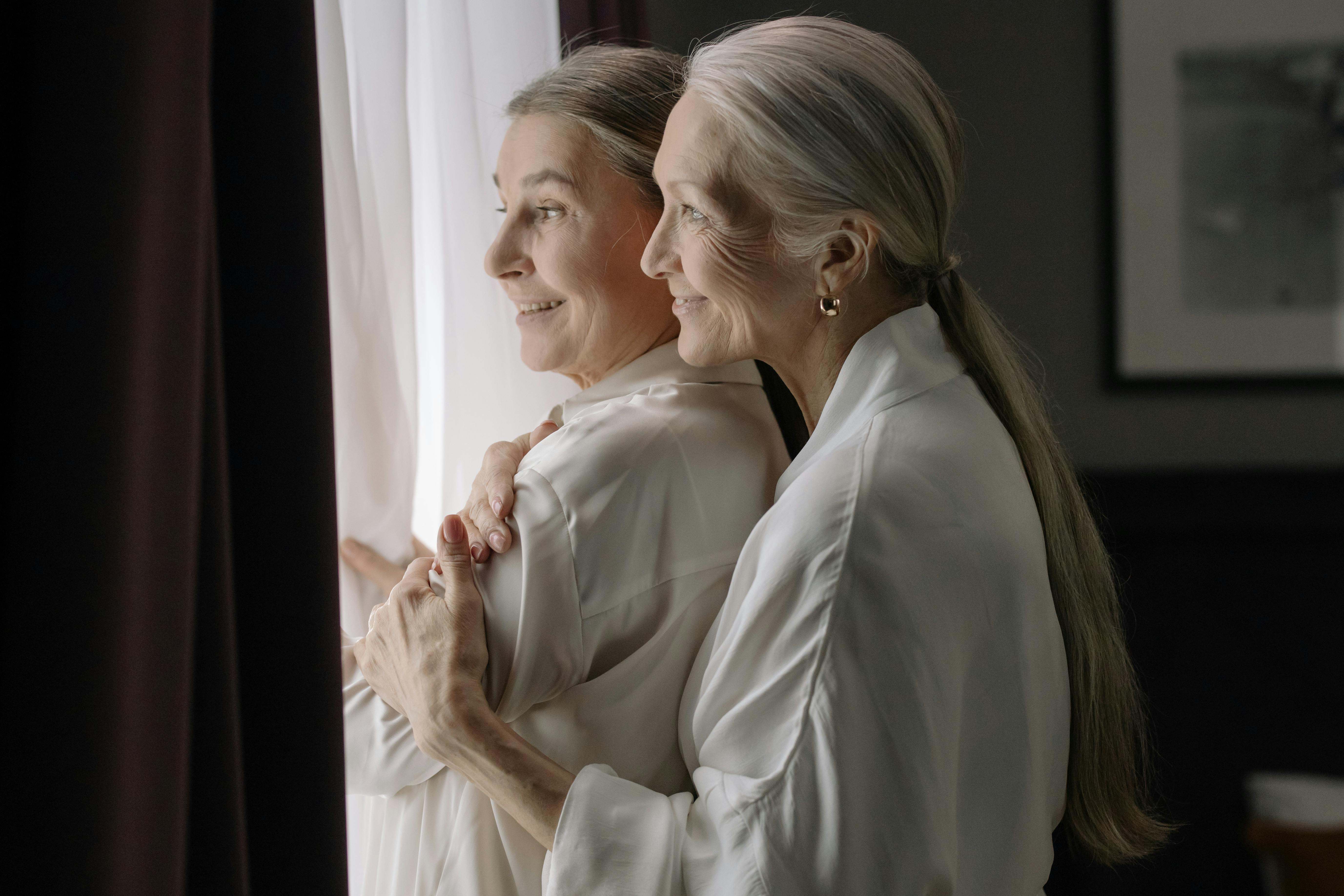 Dos personas de avanzada edad mirando por la ventana
