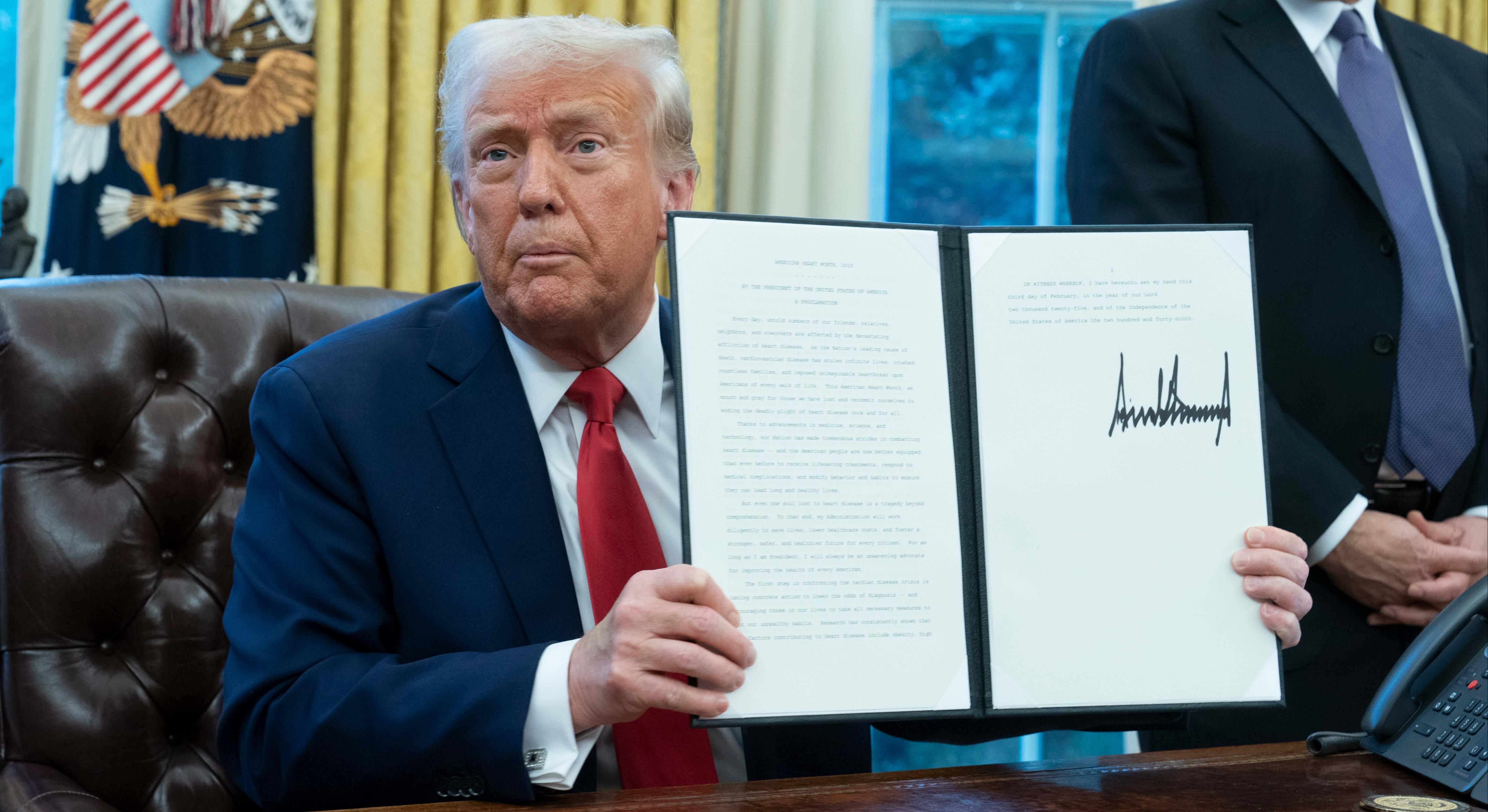 Donald Trump, presidente de EEUU, muestra un decreto firmado de su puño y letra.