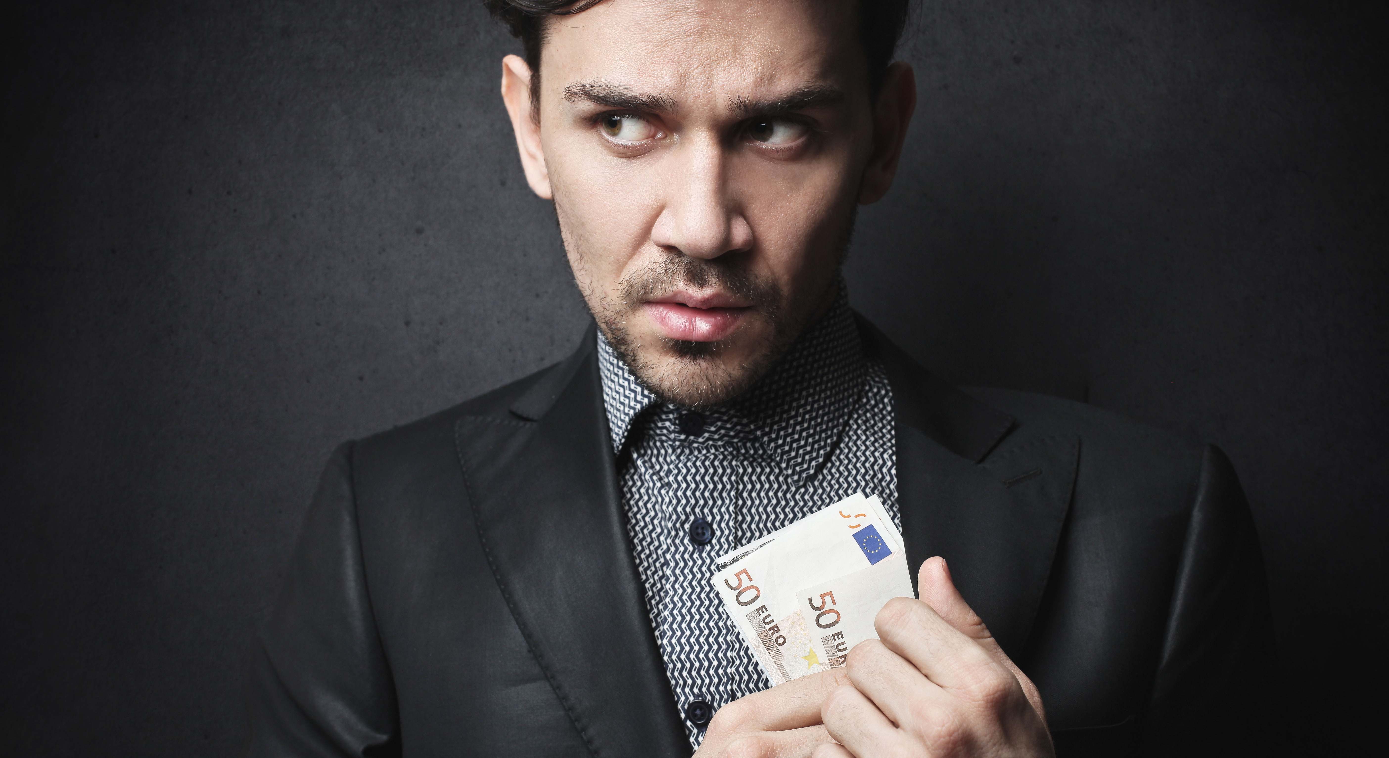 Un hombre guarda dinero en su chaqueta