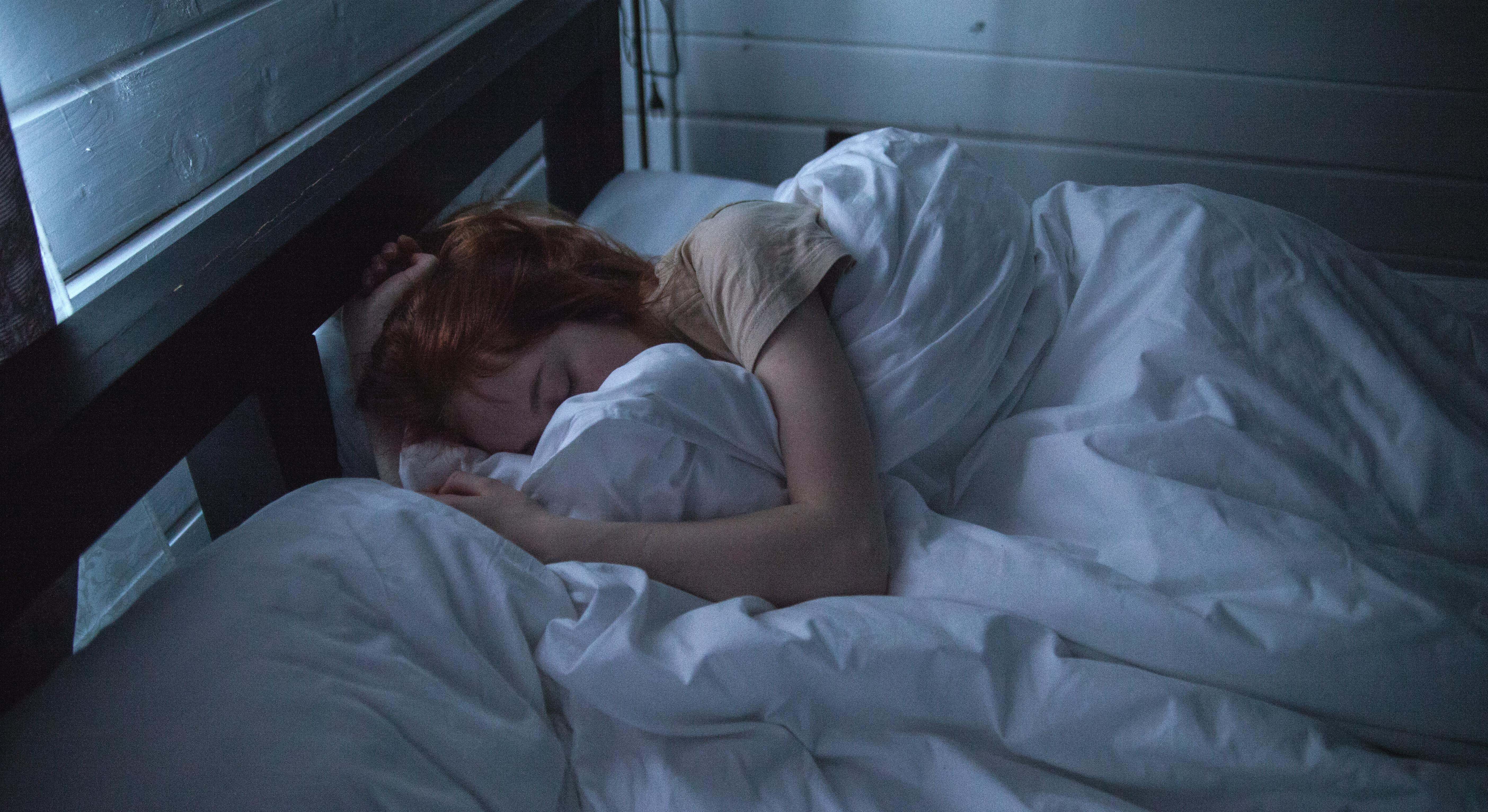 Una mujer trata de dormir por la noche, pero la resulta imposible